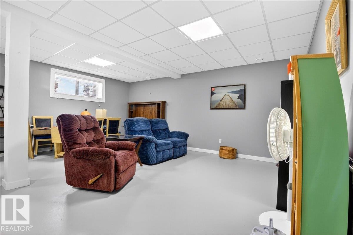 Finished room featuring light gray walls, a drop ceiling with recessed lighting, and a single horizontal window - 5019 48 Avenue, Chipman, AB - Indoor