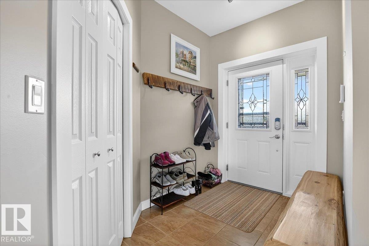 Entryway featuring a white door with decorative glass inserts, a matching sidelight, and ceramic tile flooring - 5019 48 Avenue, Chipman, AB - Indoor Photo Showing Other Room