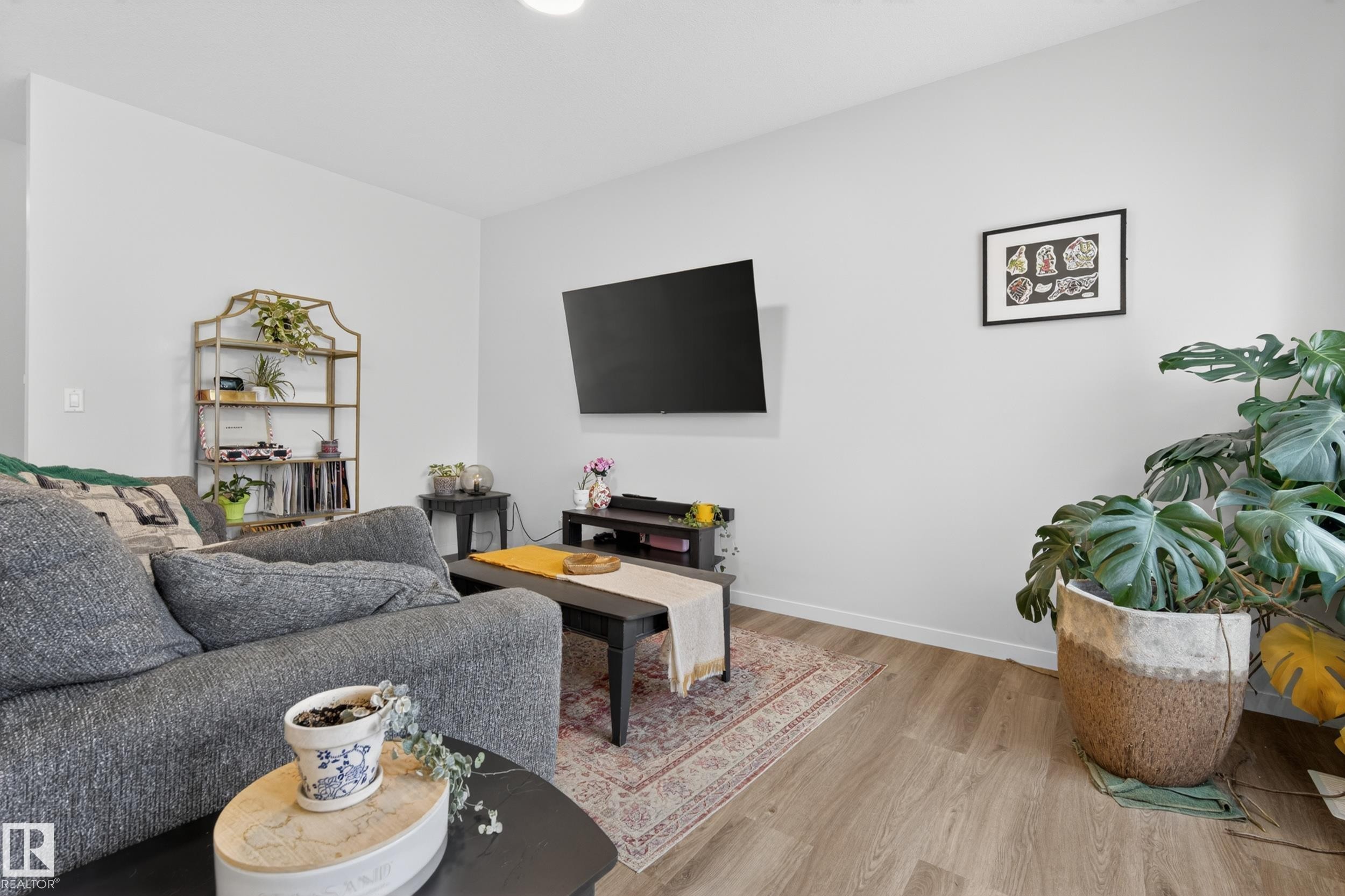 Open living area featuring light wood-finish flooring and neutral wall tones - 22836 94 Avenue, Edmonton, AB