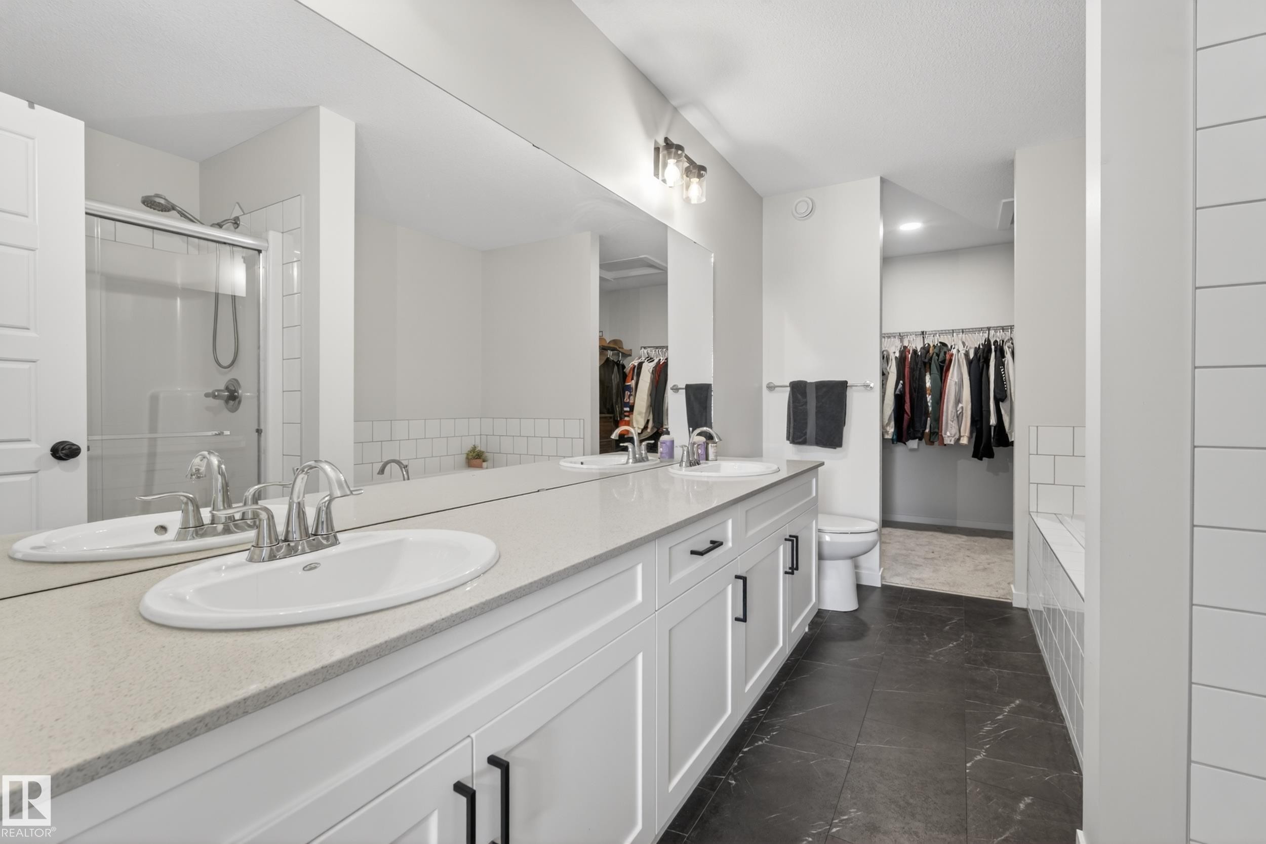 Double vanity with white cabinetry, light stone-finish countertop, and undermount sinks - 22836 94 Avenue, Edmonton, AB