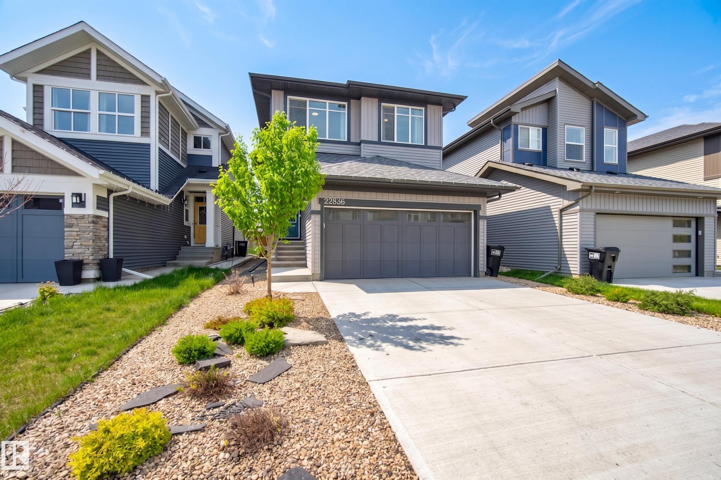 Modern two-story residence featuring a two-tone facade, attached garage, and concrete driveway - 22836 94 Avenue, Edmonton, AB