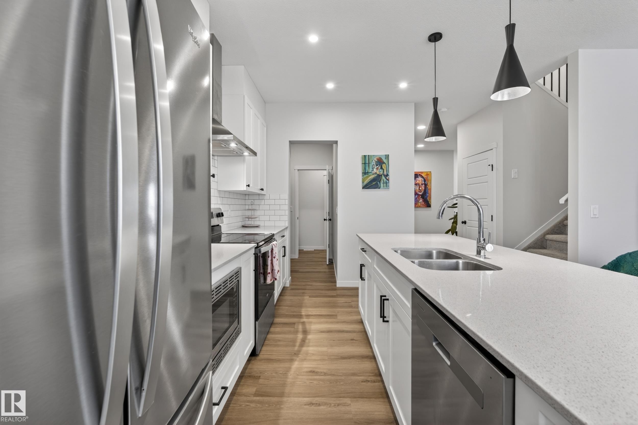 Modern kitchen featuring a large island with dual basin sink and gooseneck faucet - 22836 94 Avenue, Edmonton, AB