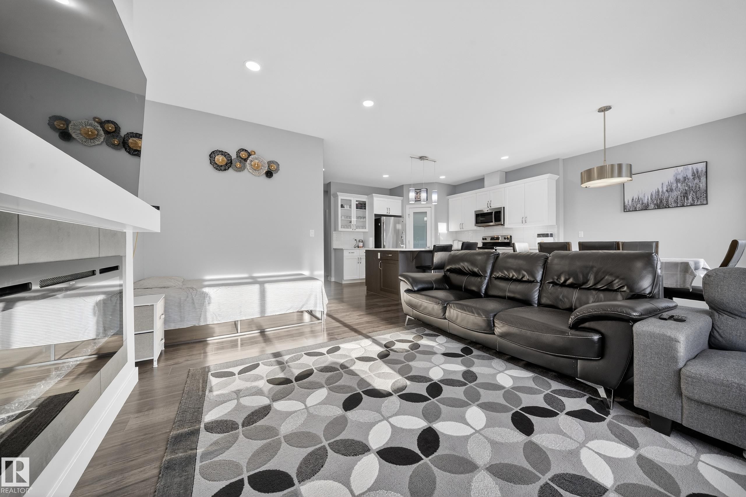 Open-concept living space featuring wood-finish flooring, recessed lighting, and a modern kitchen - 2084 Graydon Hill, Edmonton, AB