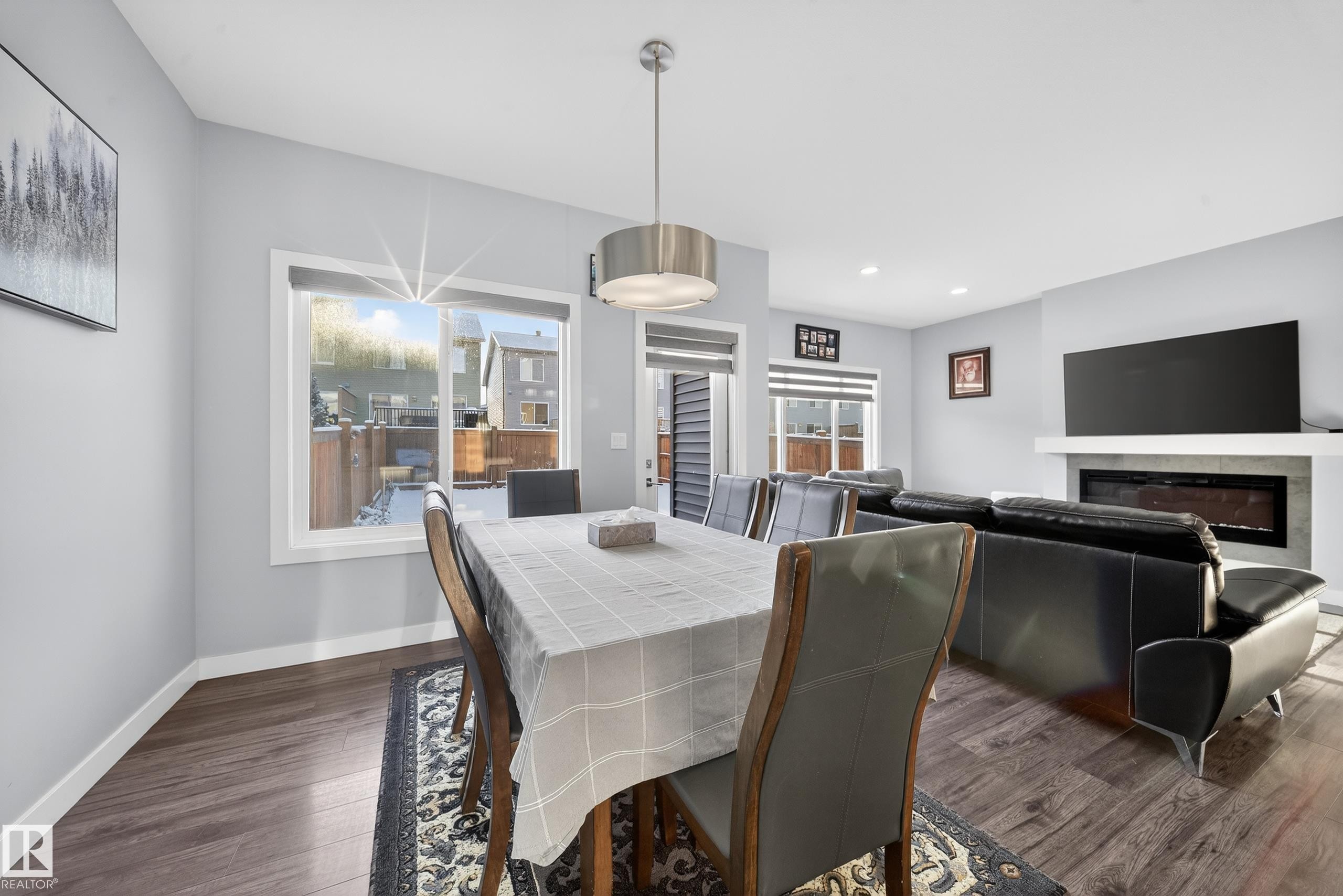 Open-concept living space featuring wood-finish flooring, a contemporary linear fireplace with a floating mantel, and recessed lighting - 2084 Graydon Hill, Edmonton, AB