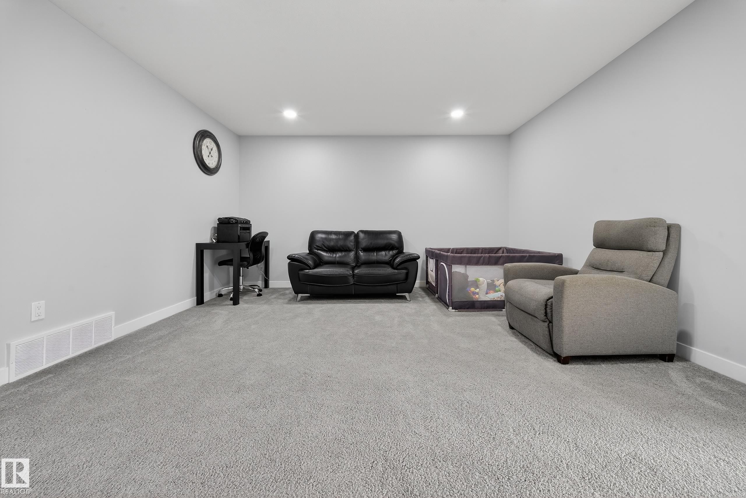Spacious room featuring light gray carpeting, recessed ceiling lighting, and crisp white baseboards - 2084 Graydon Hill, Edmonton, AB