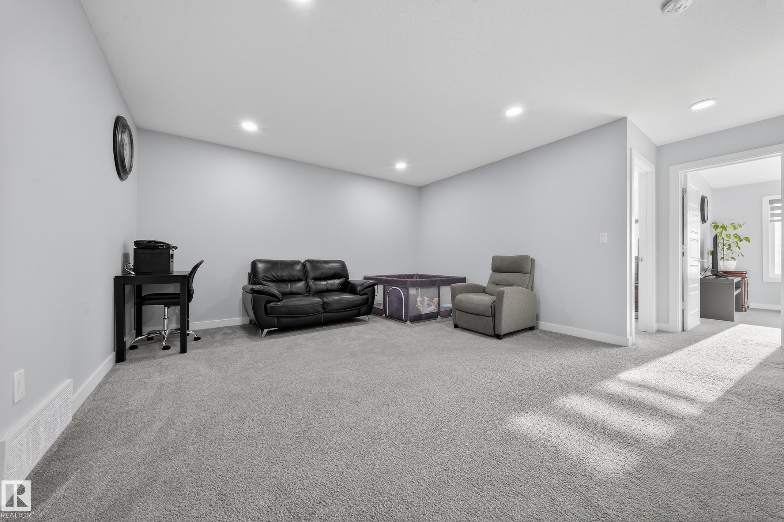 Spacious carpeted room featuring light gray walls, recessed lighting, and white baseboards - 2084 Graydon Hill, Edmonton, AB
