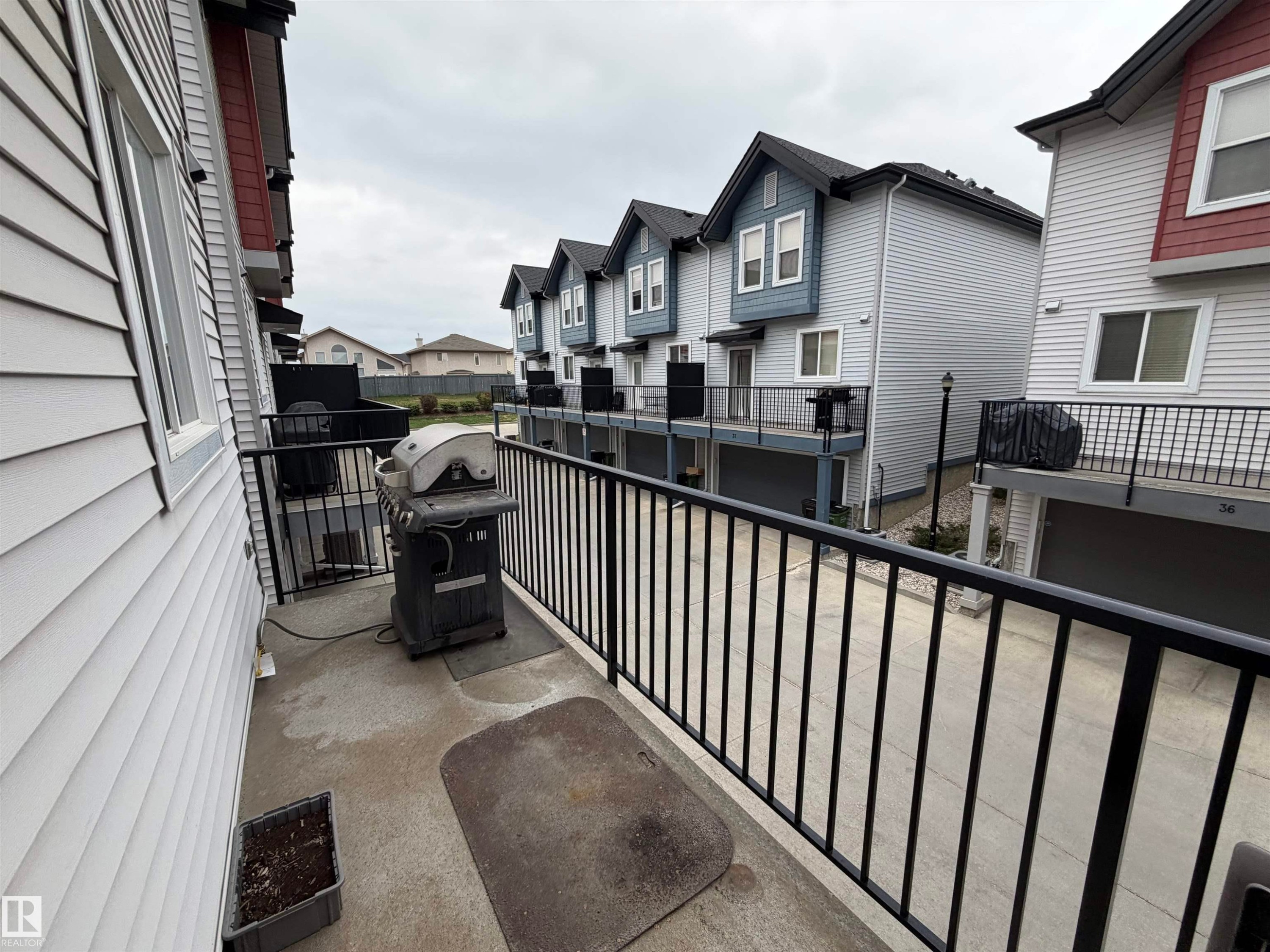 Private concrete balcony featuring black metal railings - 45 6075 Schonsee Way, Edmonton, AB