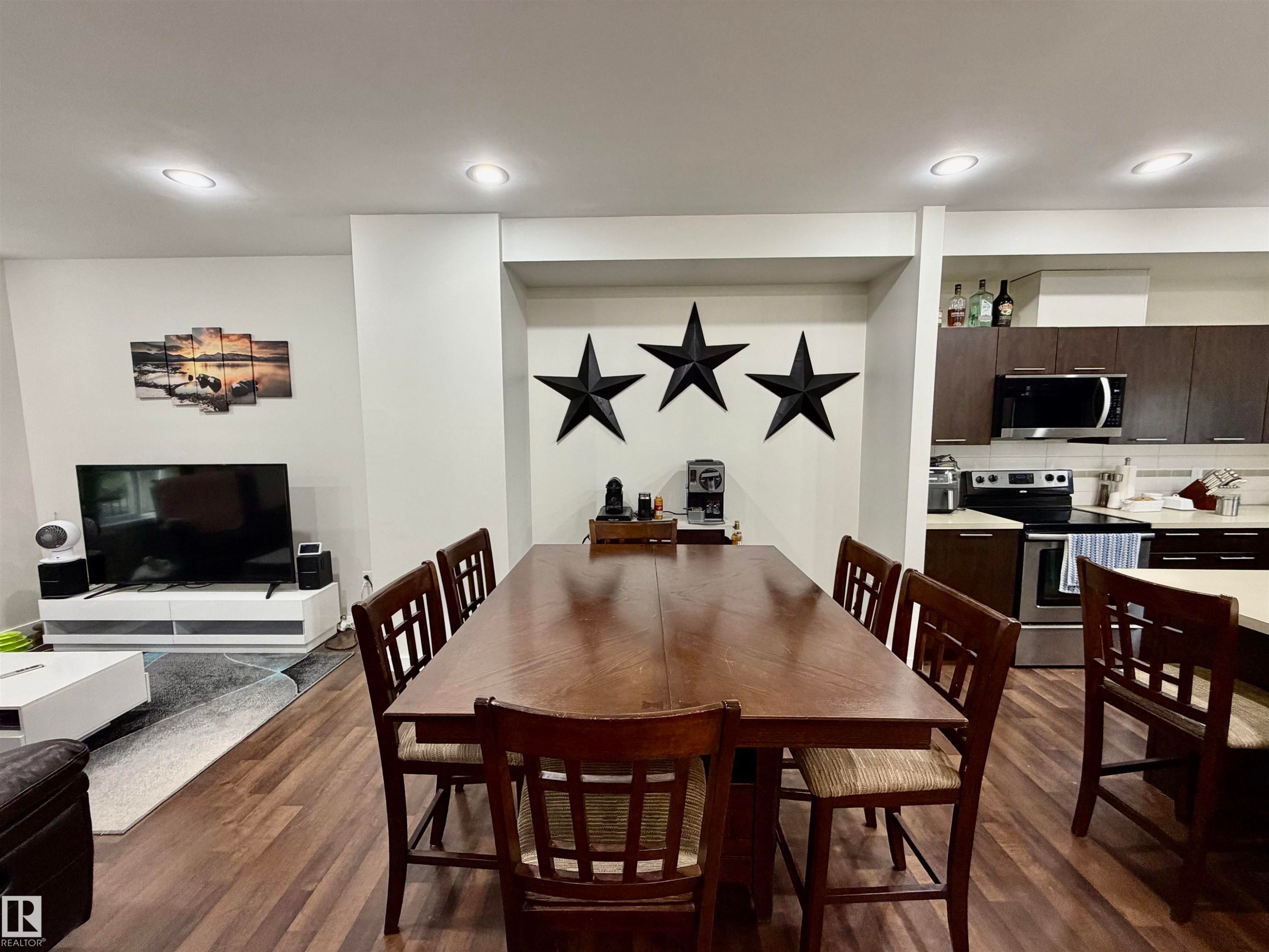 Open-concept living space featuring wood-finish flooring and recessed lighting - 45 6075 Schonsee Way, Edmonton, AB