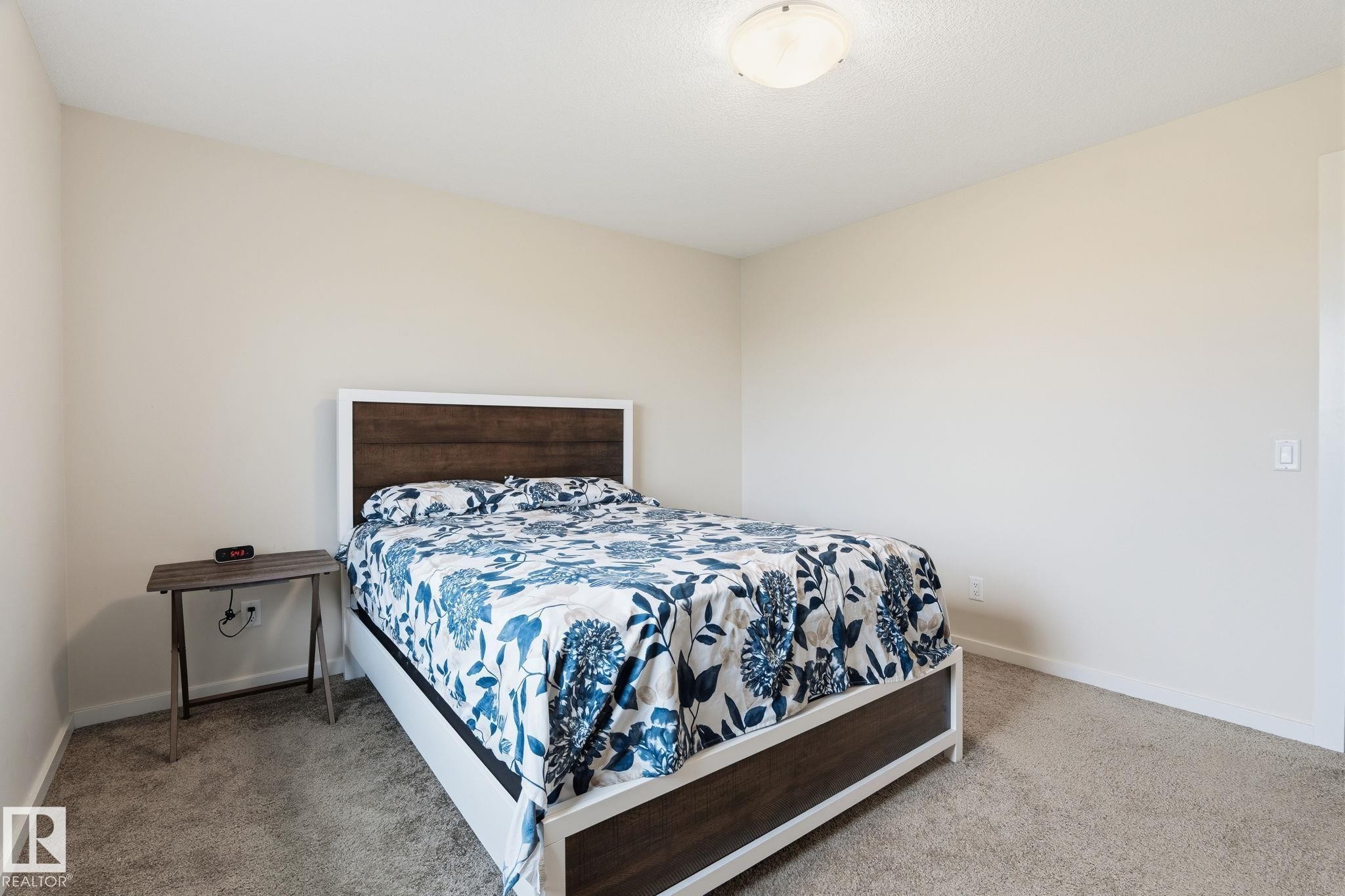 Neutral wall tones complement the ceiling-mounted light fixture and carpeted flooring - 20011 26, Edmonton, AB