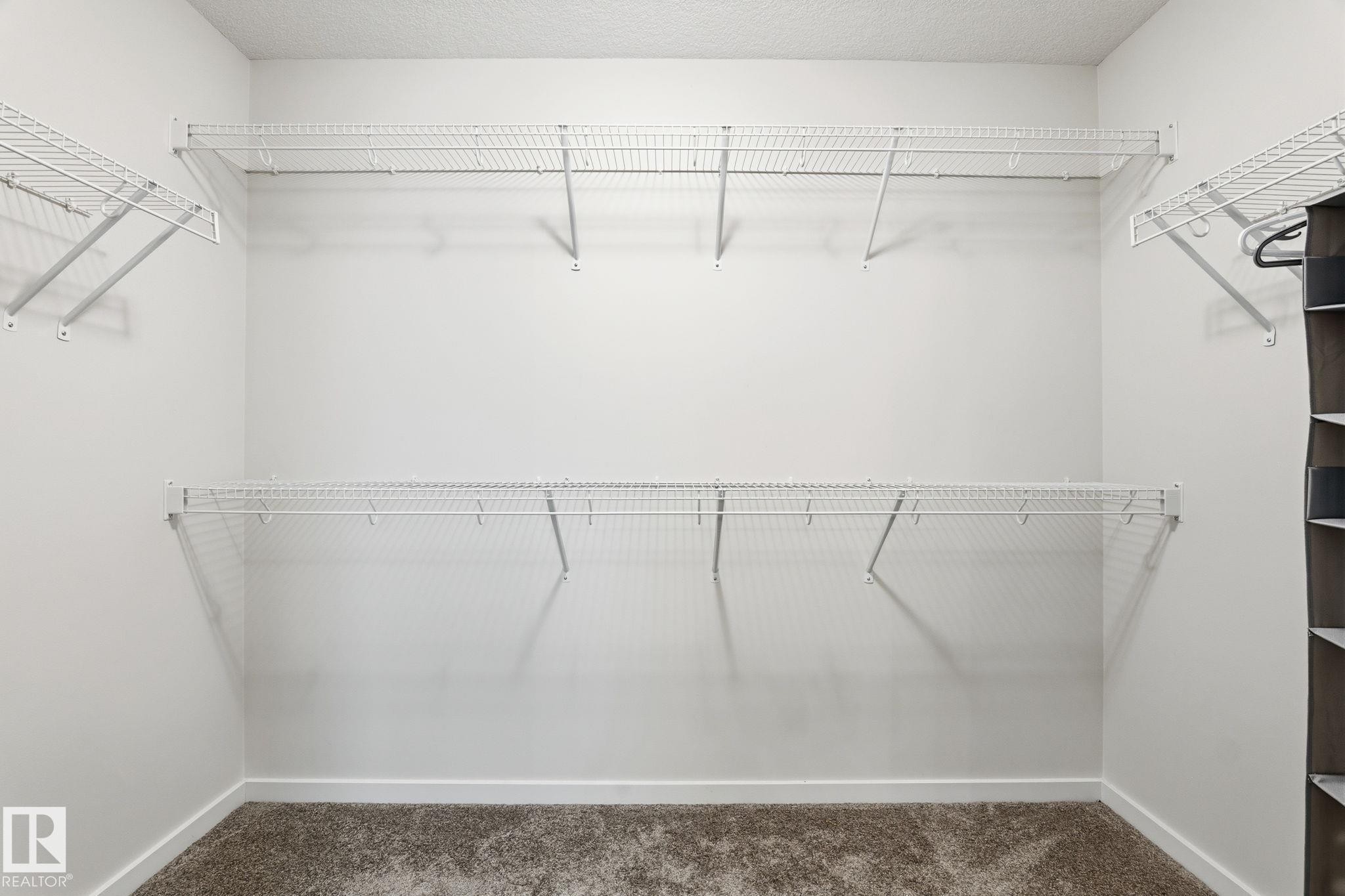 White wire shelving system installed in a closet with light gray walls and carpet flooring - 20011 26, Edmonton, AB