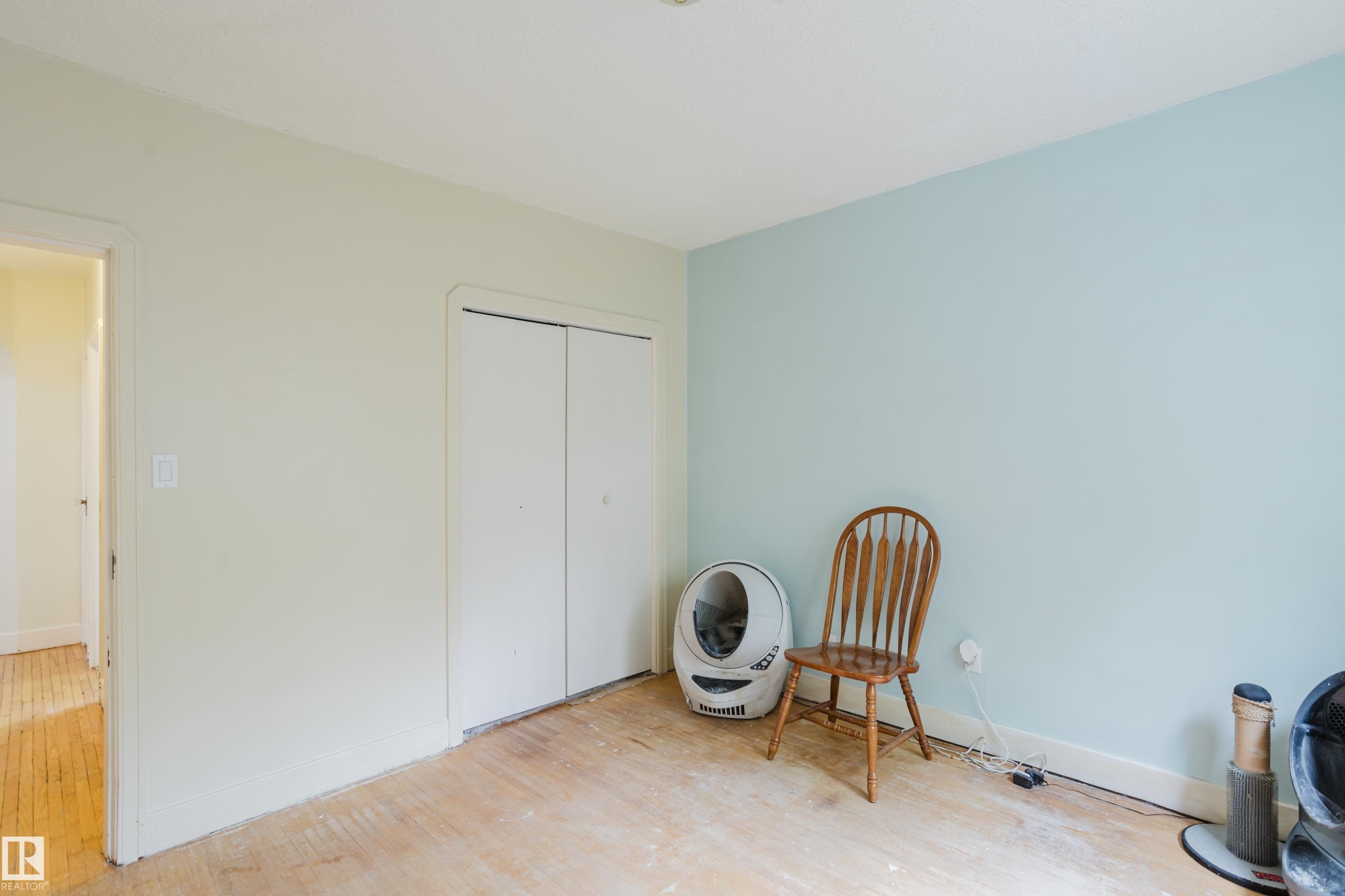 Room featuring bi-fold closet doors, light-toned wall finishes, and exposed subflooring - 11158 65 Street, Edmonton, AB