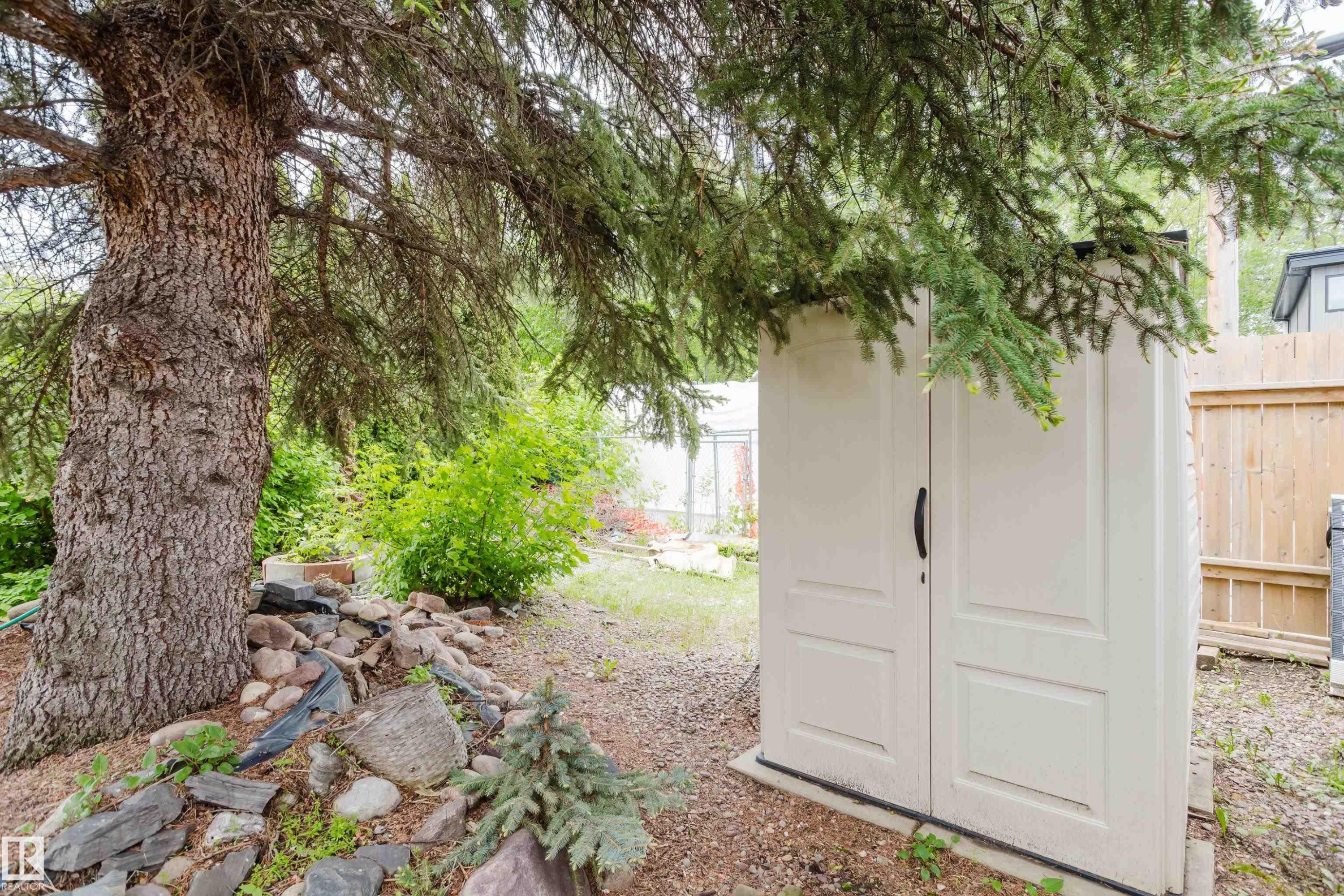 Outdoor storage shed with double doors, set on a gravel and dirt ground - 11158 65 Street, Edmonton, AB