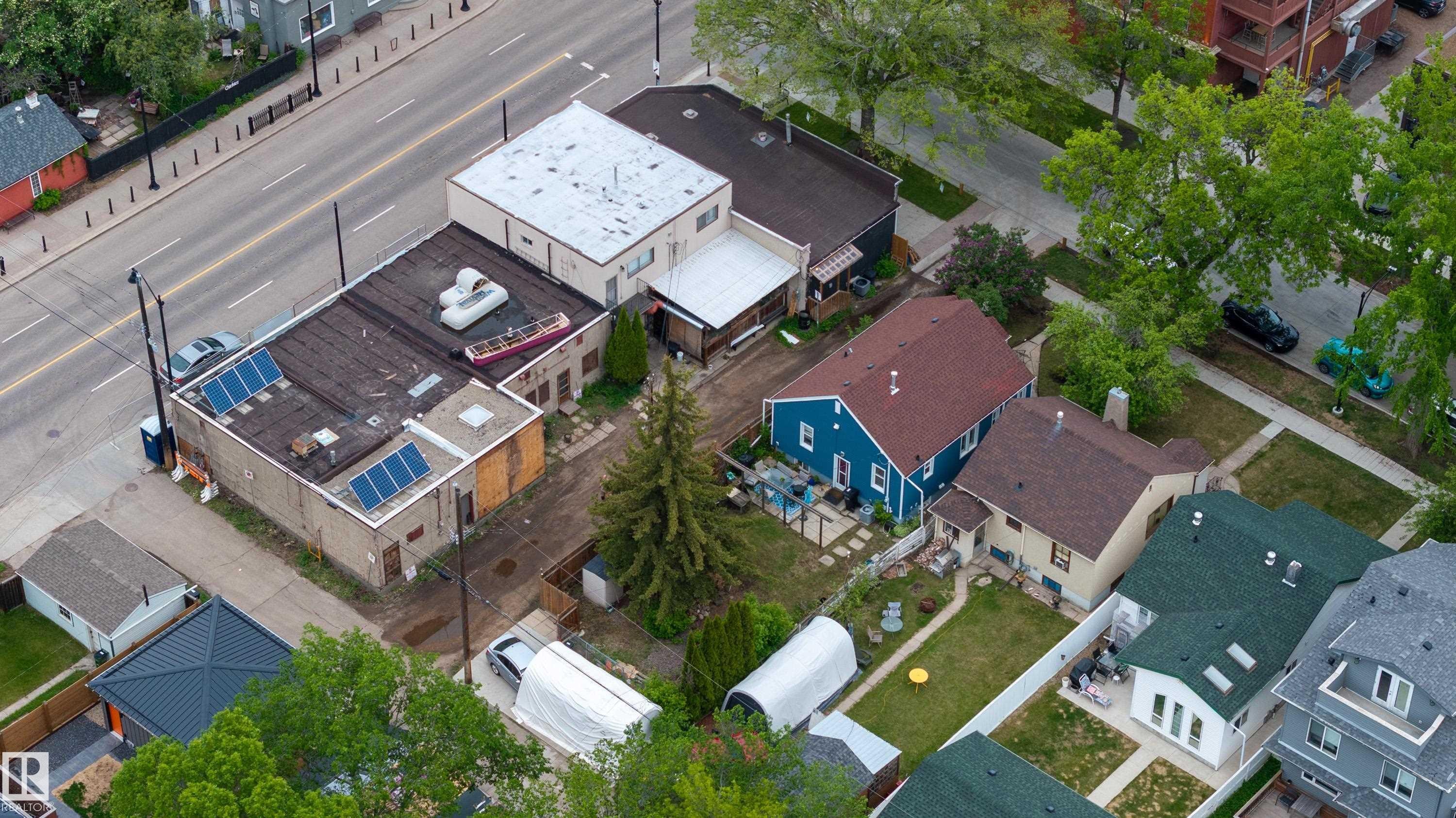 Aerial perspective showcasing a commercial building with a flat roof featuring solar panels - 11158 65 Street, Edmonton, AB