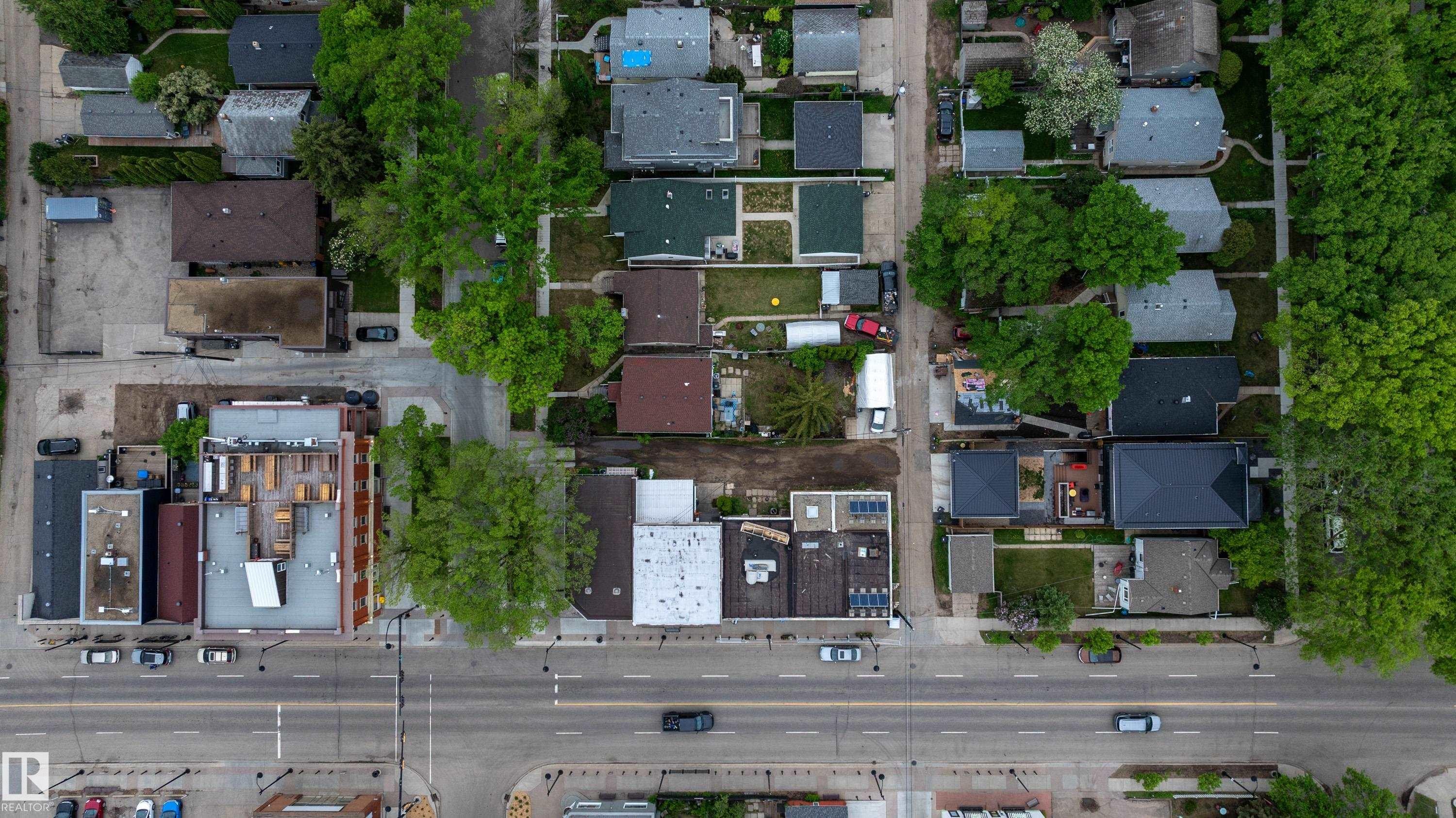 Aerial perspective showcasing a mixed-use neighborhood with residential properties and commercial buildings - 11158 65 Street, Edmonton, AB