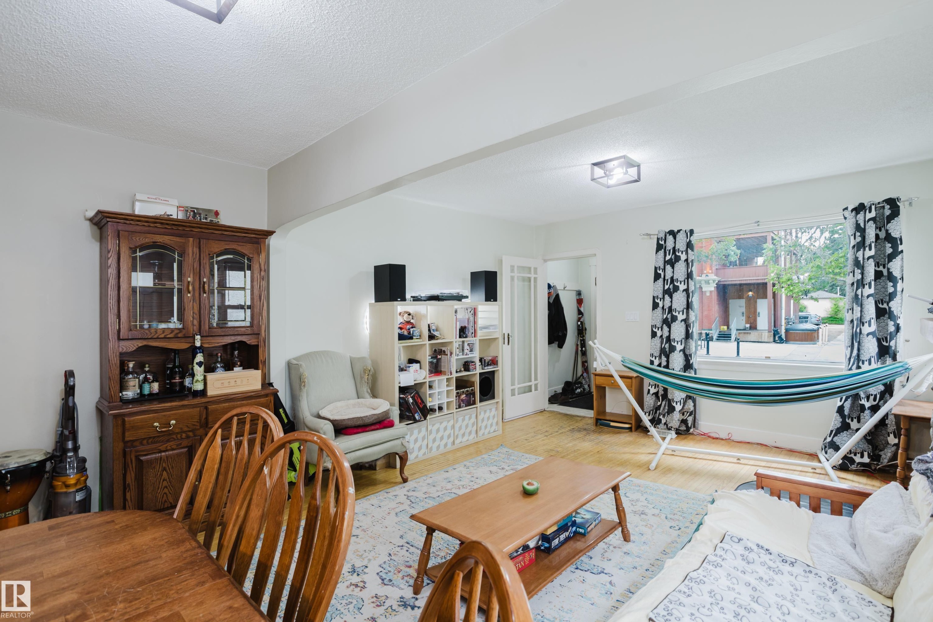 Bright living space featuring light-toned wood-finish flooring and white walls - 11158 65 Street, Edmonton, AB