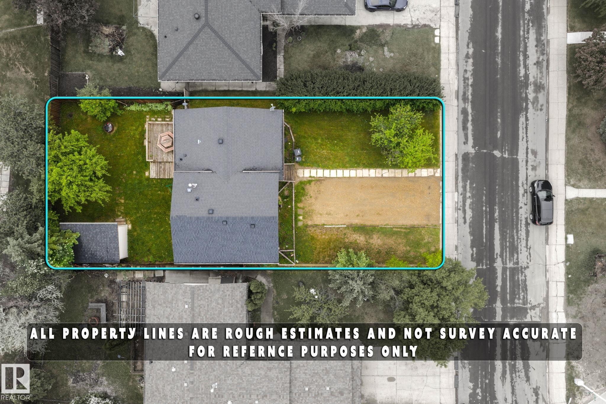 Aerial perspective showcasing the property's perimeter, featuring a main residence with a dark-toned roof, a detached shed, a wooden deck, and a combination of grass and unpaved areas - 2045 46St, Edmonton, AB