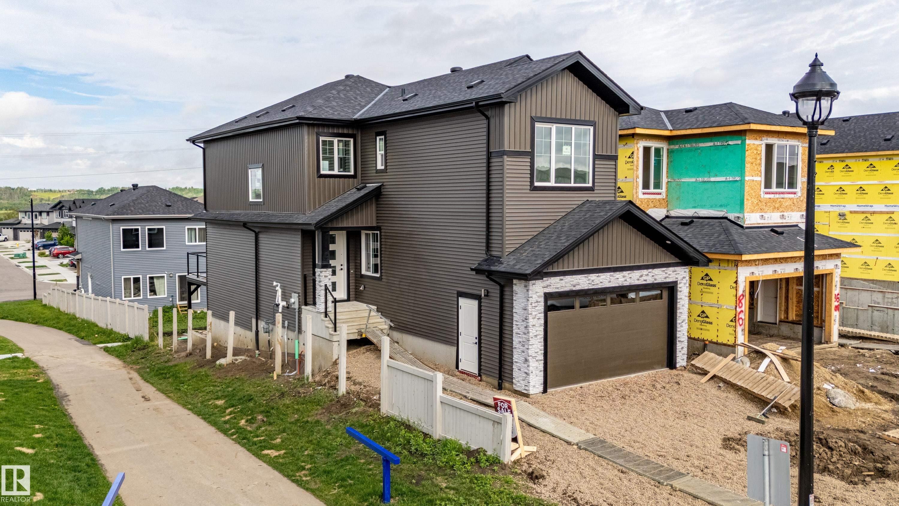 Contemporary two-story residence featuring dark gray siding and a black shingle roof - 82 Wynn Rd, Fort Saskatchewan, AB