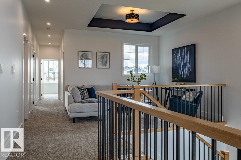 Upper-level area featuring a tray ceiling with a dark accent, a contemporary drum pendant light, and recessed lighting - 82 Wynn Rd, Fort Saskatchewan, AB