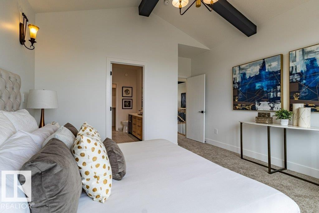 Bedroom featuring vaulted ceilings with exposed dark beams and a contemporary chandelier - 82 Wynn Rd, Fort Saskatchewan, AB