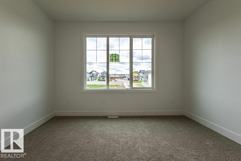 Clean interior space featuring neutral wall paint, white trim, and carpet flooring - 82 Wynn Rd, Fort Saskatchewan, AB