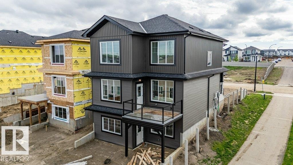 Contemporary multi-level exterior with dark gray vertical and horizontal siding - 82 Wynn Rd, Fort Saskatchewan, AB