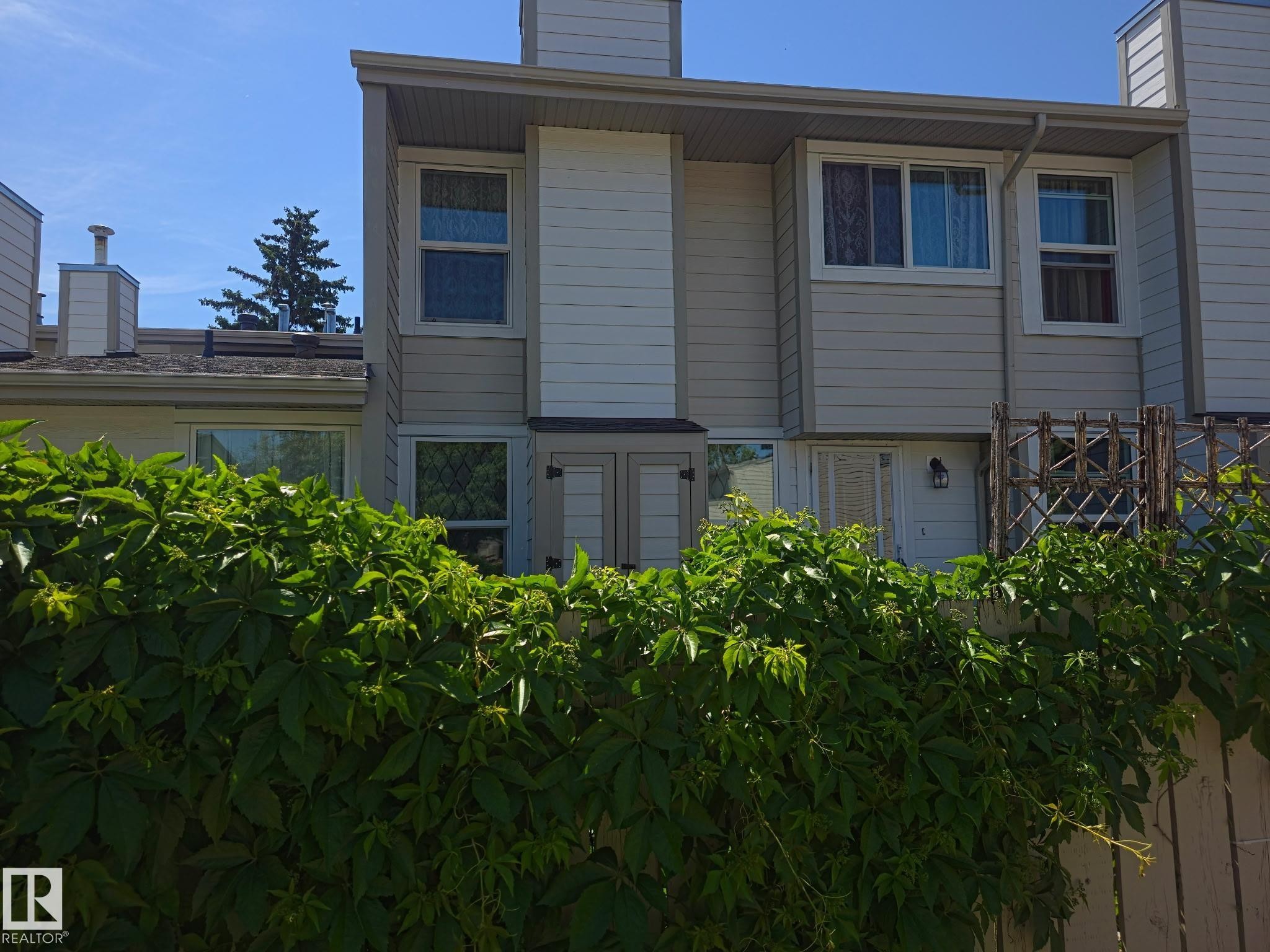 Multi-level townhouse with light-colored siding and white trim - 1128 Knottwood Road E, Edmonton, AB