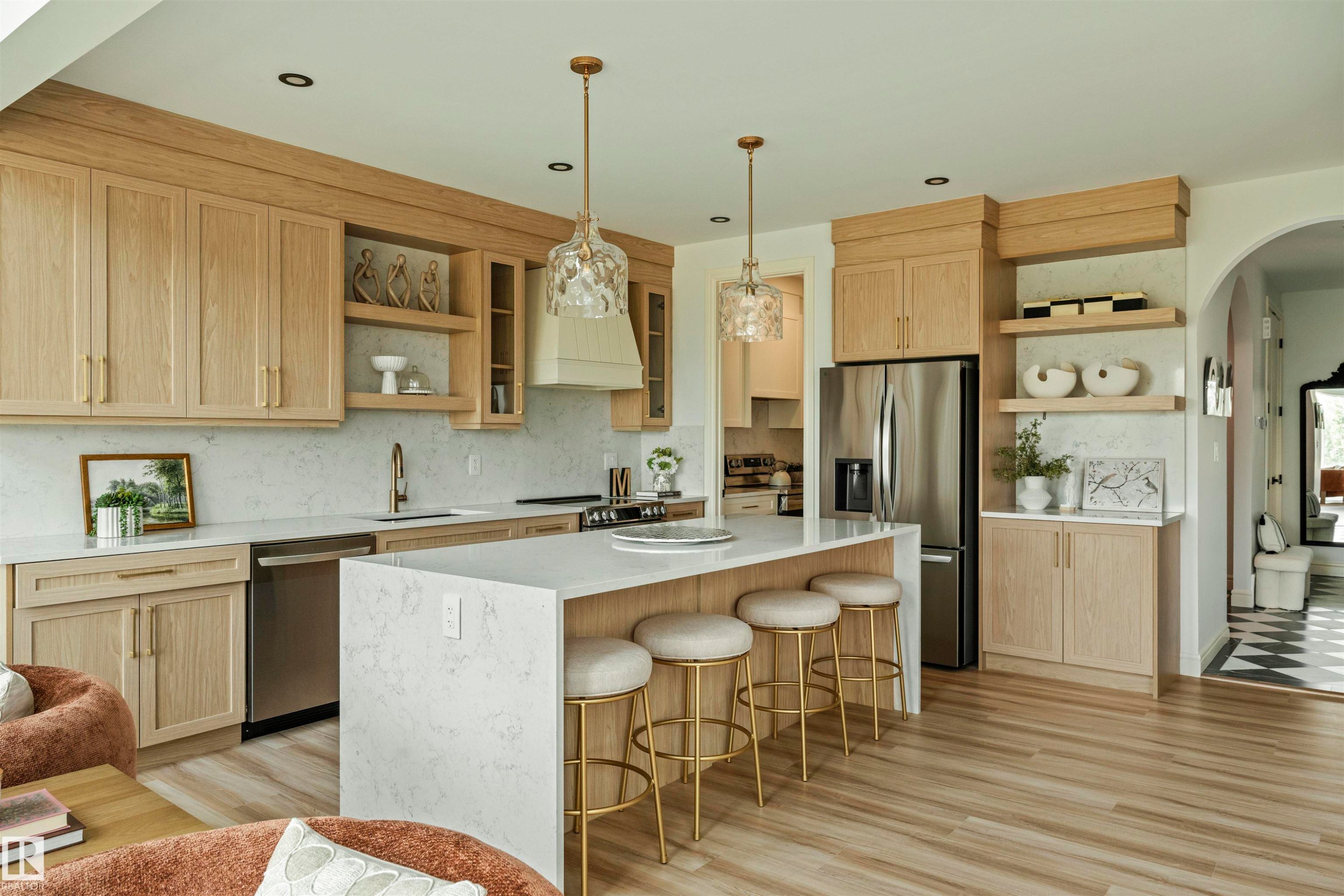 Central kitchen island with waterfall countertop, complemented by light wood-finish cabinetry - 3329 Chickadee Drive, Edmonton, AB