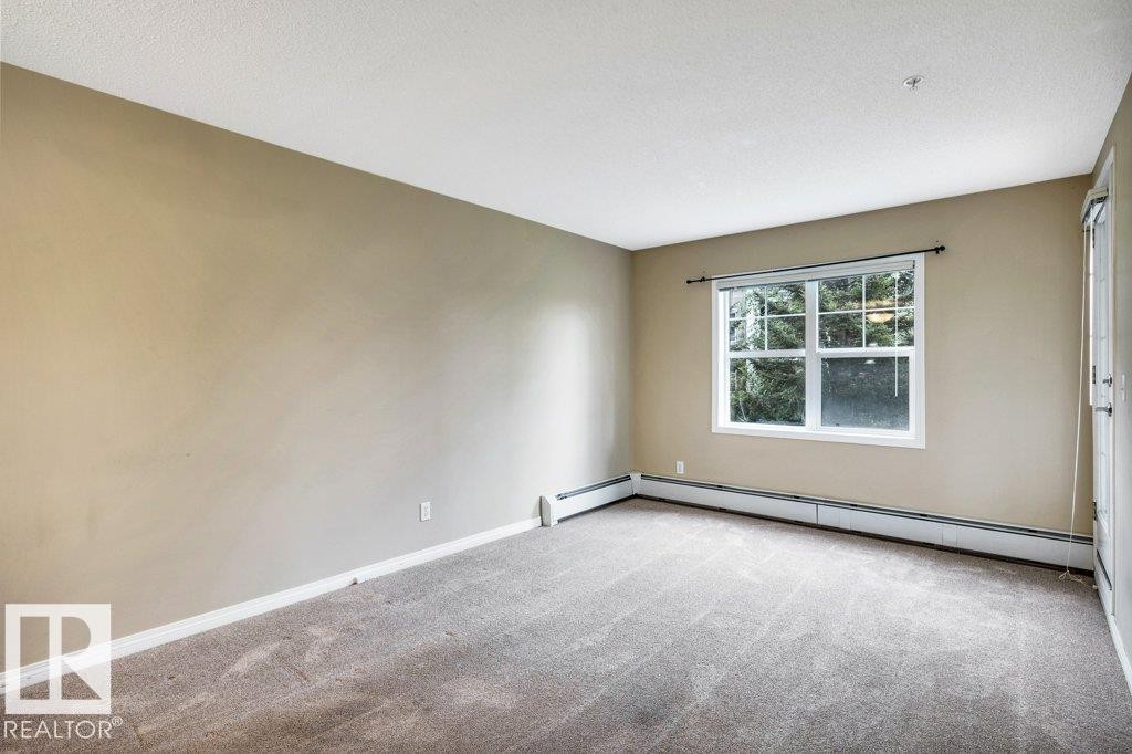 Carpeted room featuring neutral wall tones and a white ceiling - 116 630 Mcallister Loop, Edmonton, AB