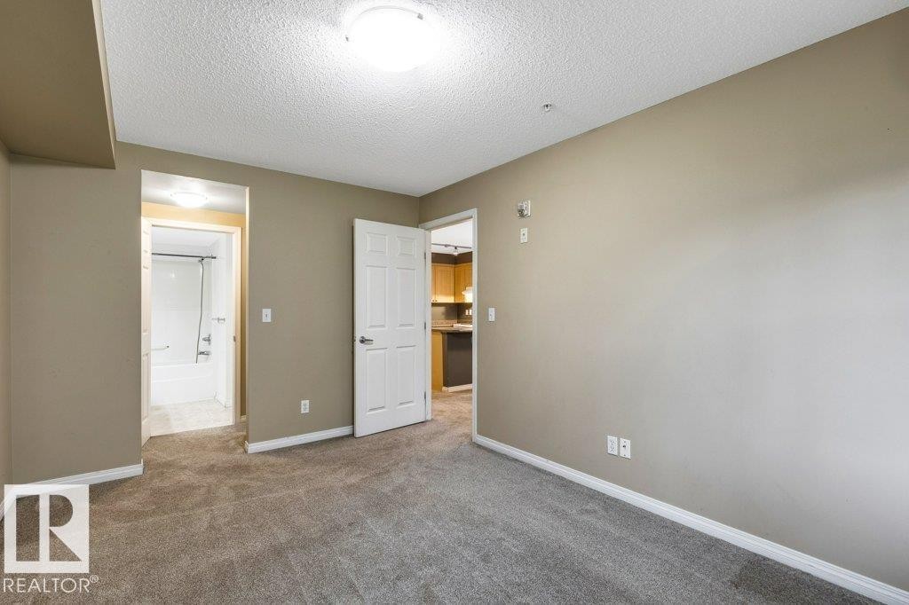 Bedroom with neutral wall paint and gray carpeting - 116 630 Mcallister Loop, Edmonton, AB