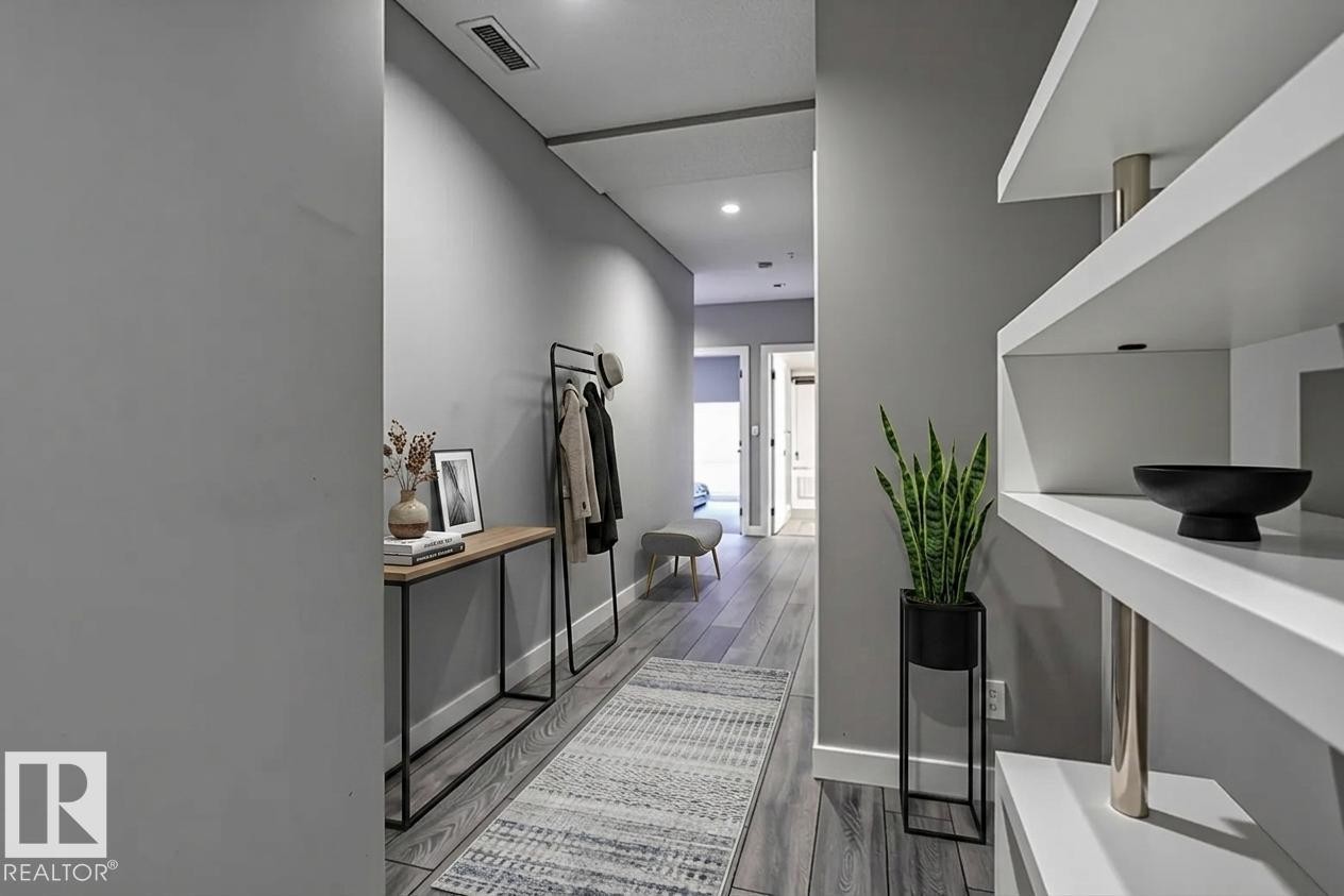 Hallway featuring wood-finish flooring, recessed lighting, and built-in shelving - 401 10238 103 Street, Edmonton, AB - Indoor Photo Showing Other Room