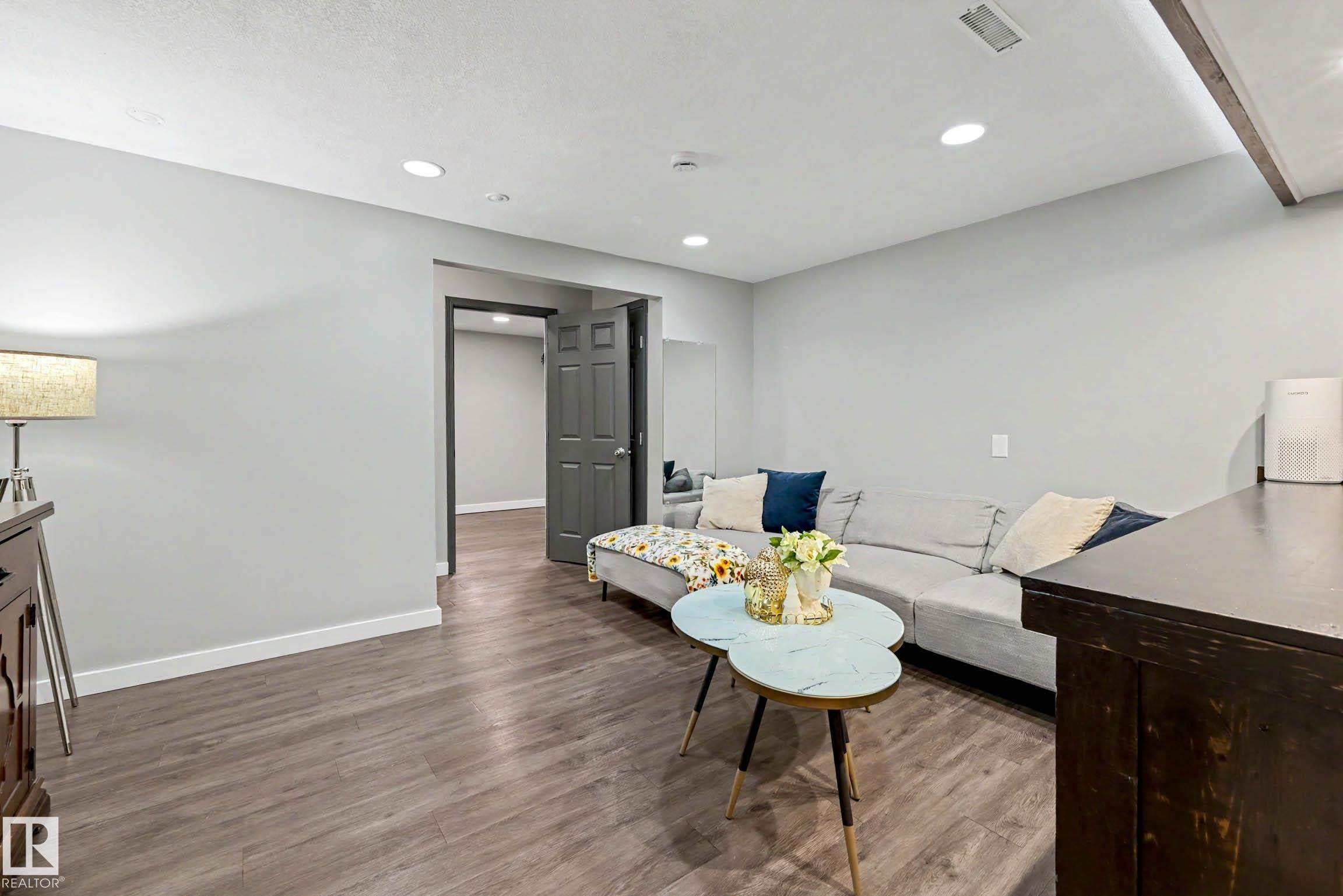 Spacious area featuring wood-finish flooring, recessed lighting, and a neutral wall palette - 12115 40 Avenue Nw, Edmonton, AB