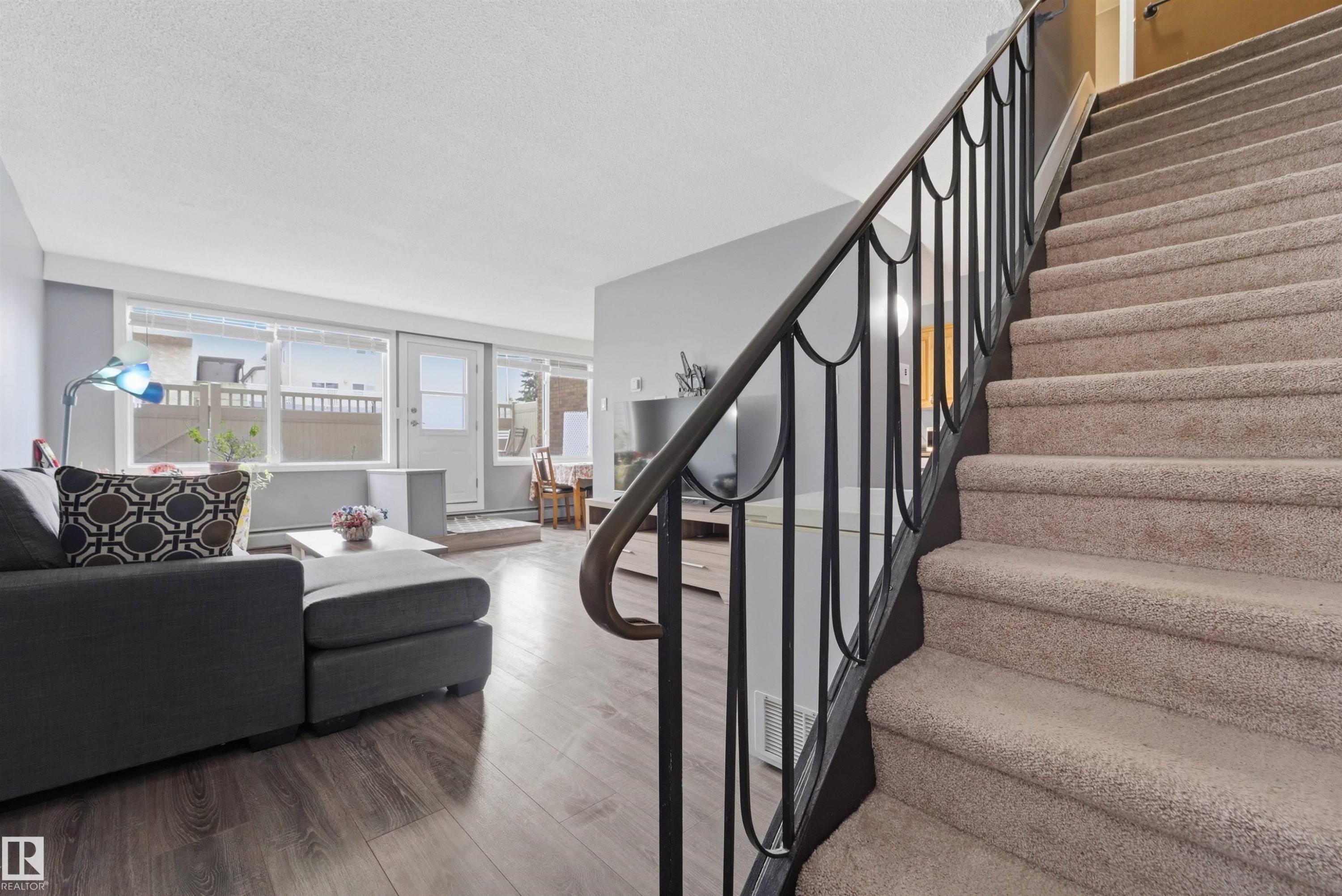 Carpeted staircase with black wrought iron railing - #110 7805 159 St Nw, Edmonton, AB