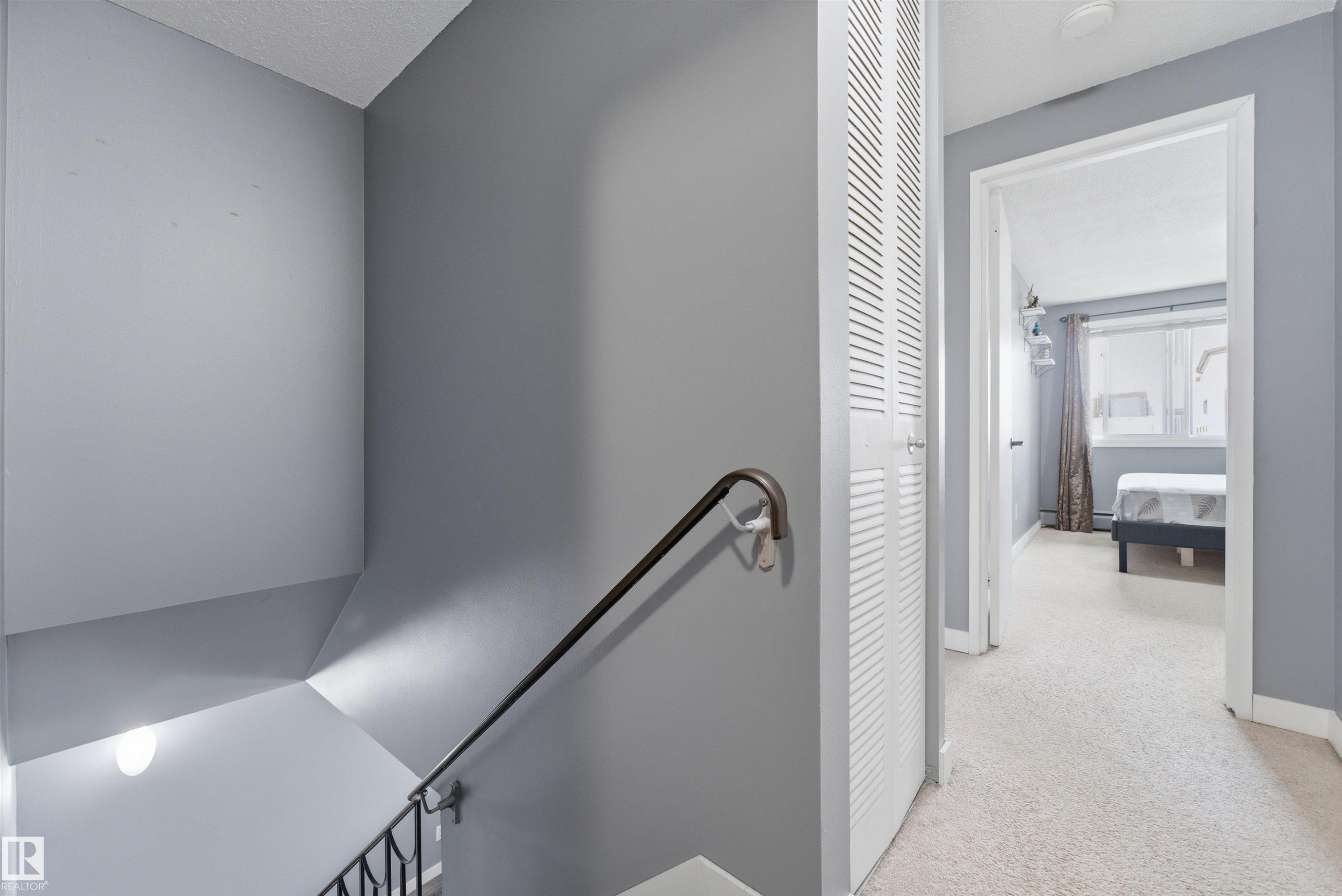 Upper-level hallway featuring light gray walls and plush carpeting - #110 7805 159 St Nw, Edmonton, AB