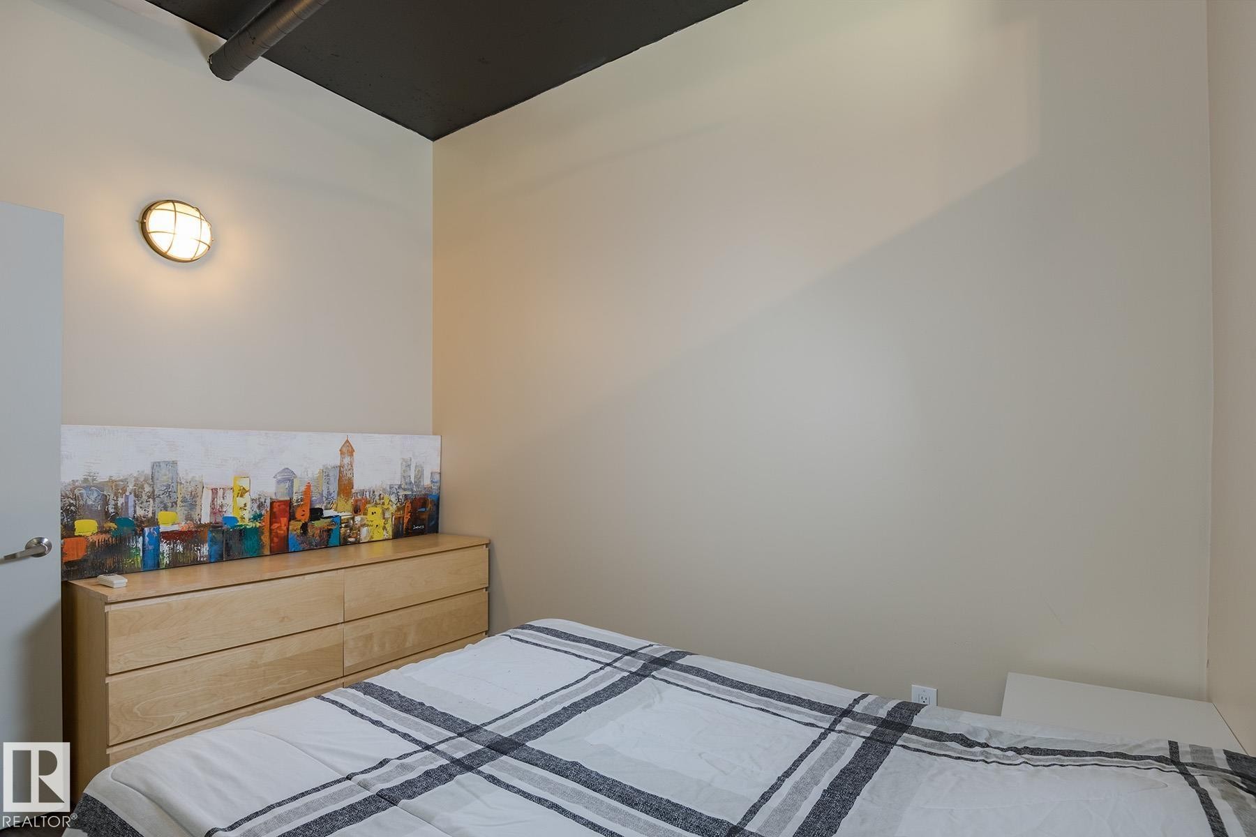 Cream-painted walls with exposed dark ceiling ductwork - 411 10024 Jasper Avenue, Edmonton, AB