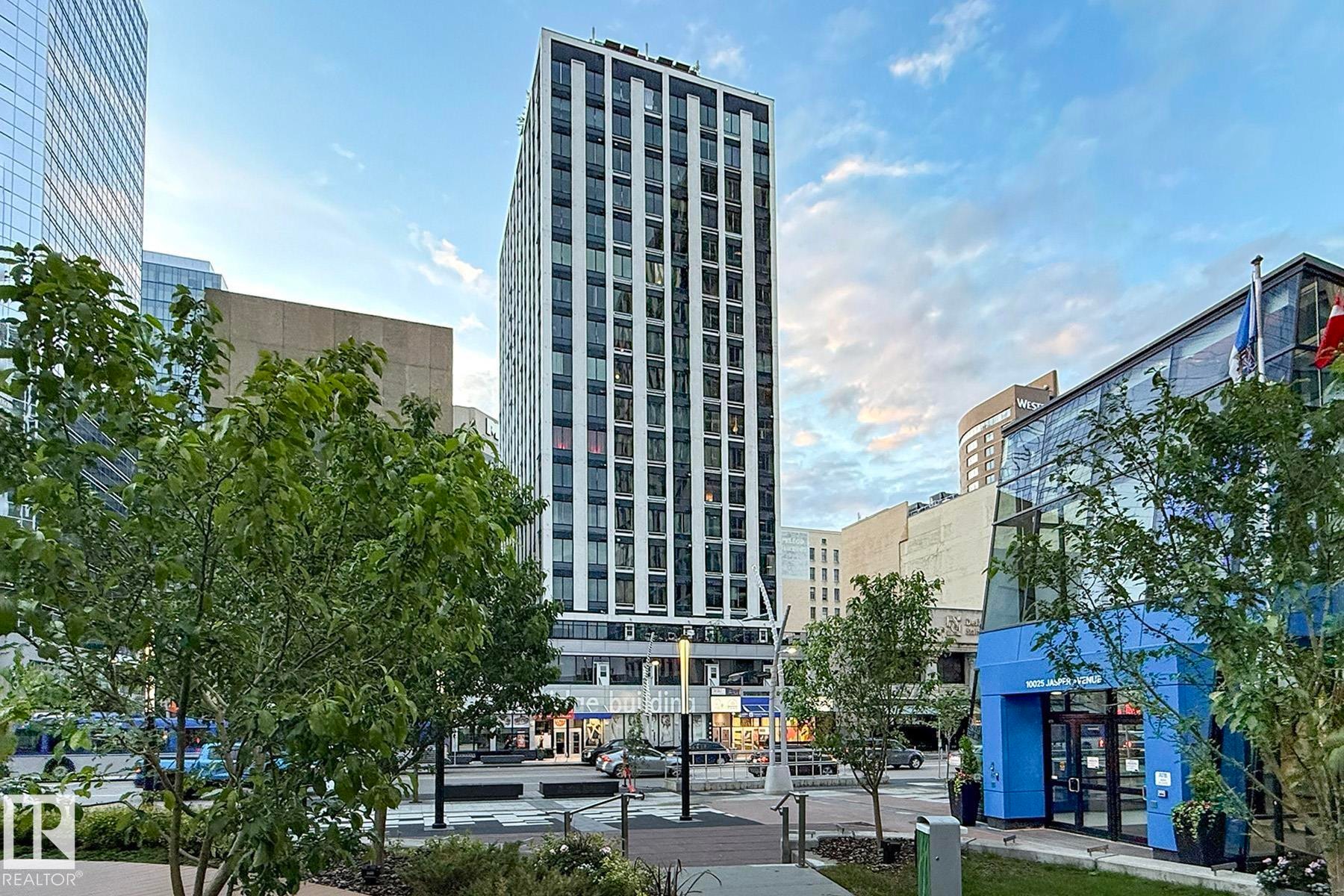Modern high-rise building featuring a white and dark facade with a grid of windows - #412 10024 Jasper Av Nw, Edmonton, AB - Outdoor With Facade