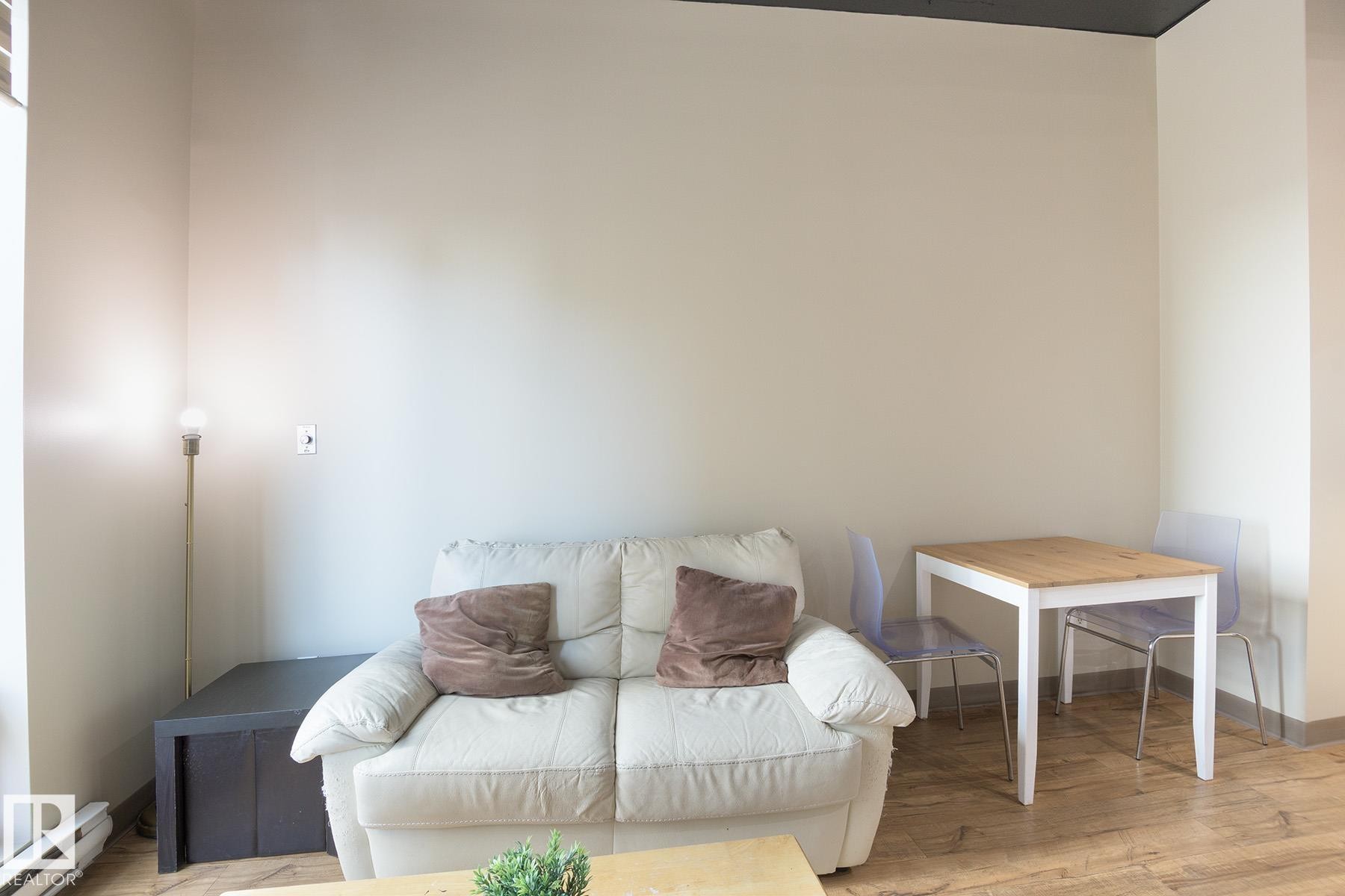 Room featuring light-toned walls and wood-finish flooring - #412 10024 Jasper Av Nw, Edmonton, AB - Indoor