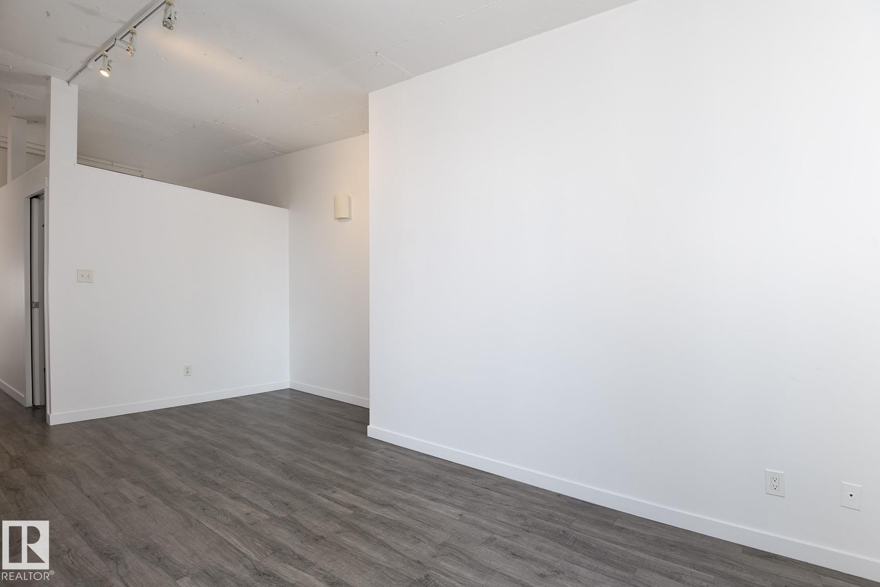 Open concept interior with wood-finish flooring and white walls - 910 10024 Jasper Avenue, Edmonton, AB
