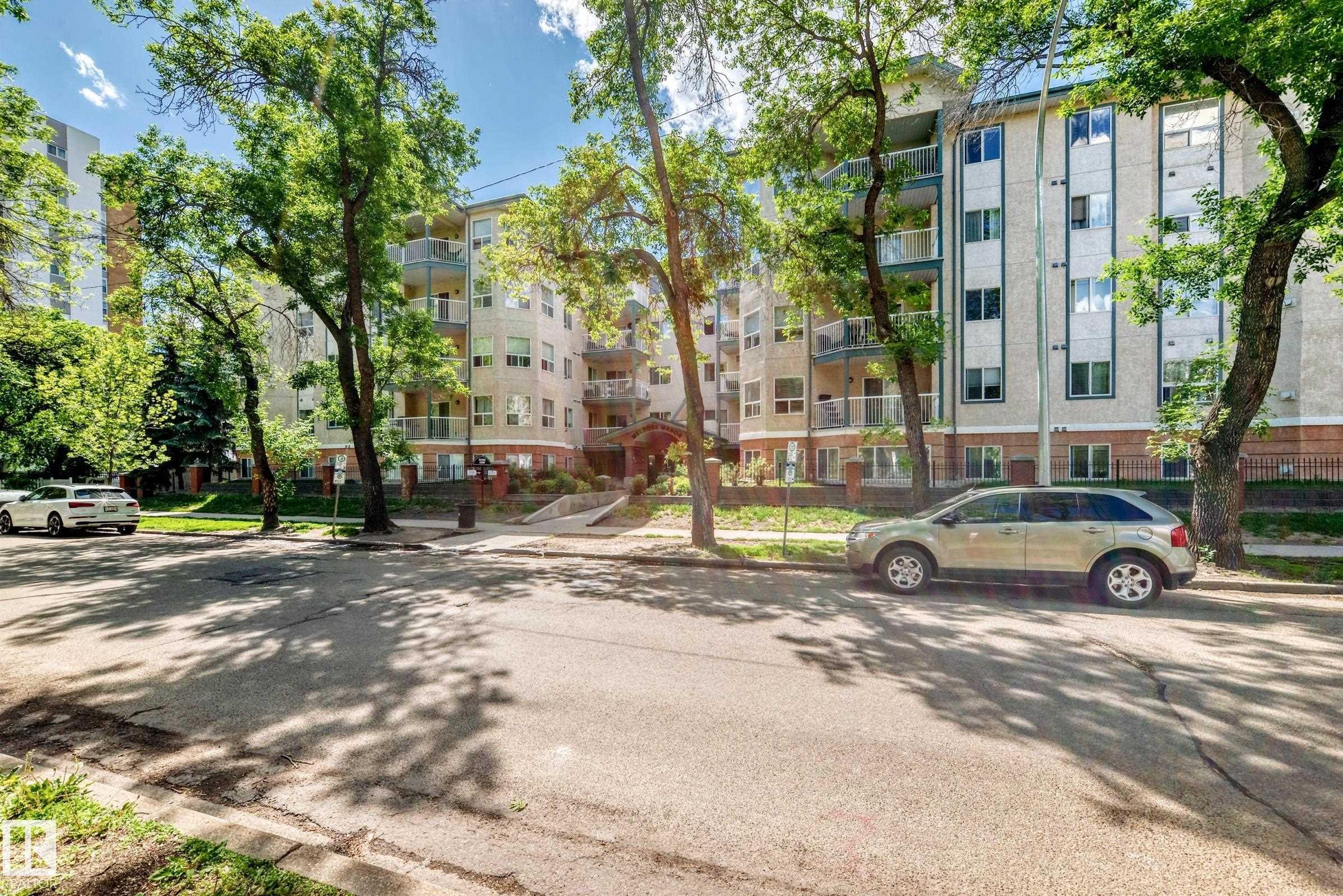 Multi-story residential building featuring a light-colored facade with contrasting vertical window sections - 214 9938 104 Street, Edmonton, AB