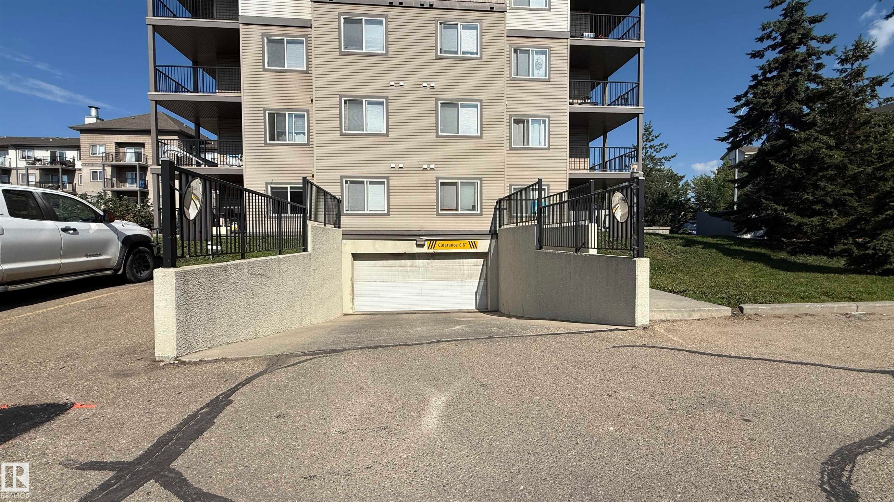 Multi-story building featuring exterior siding, multiple windows, and balconies with black railings - 133 301 Clareview Station Drive, Edmonton, AB