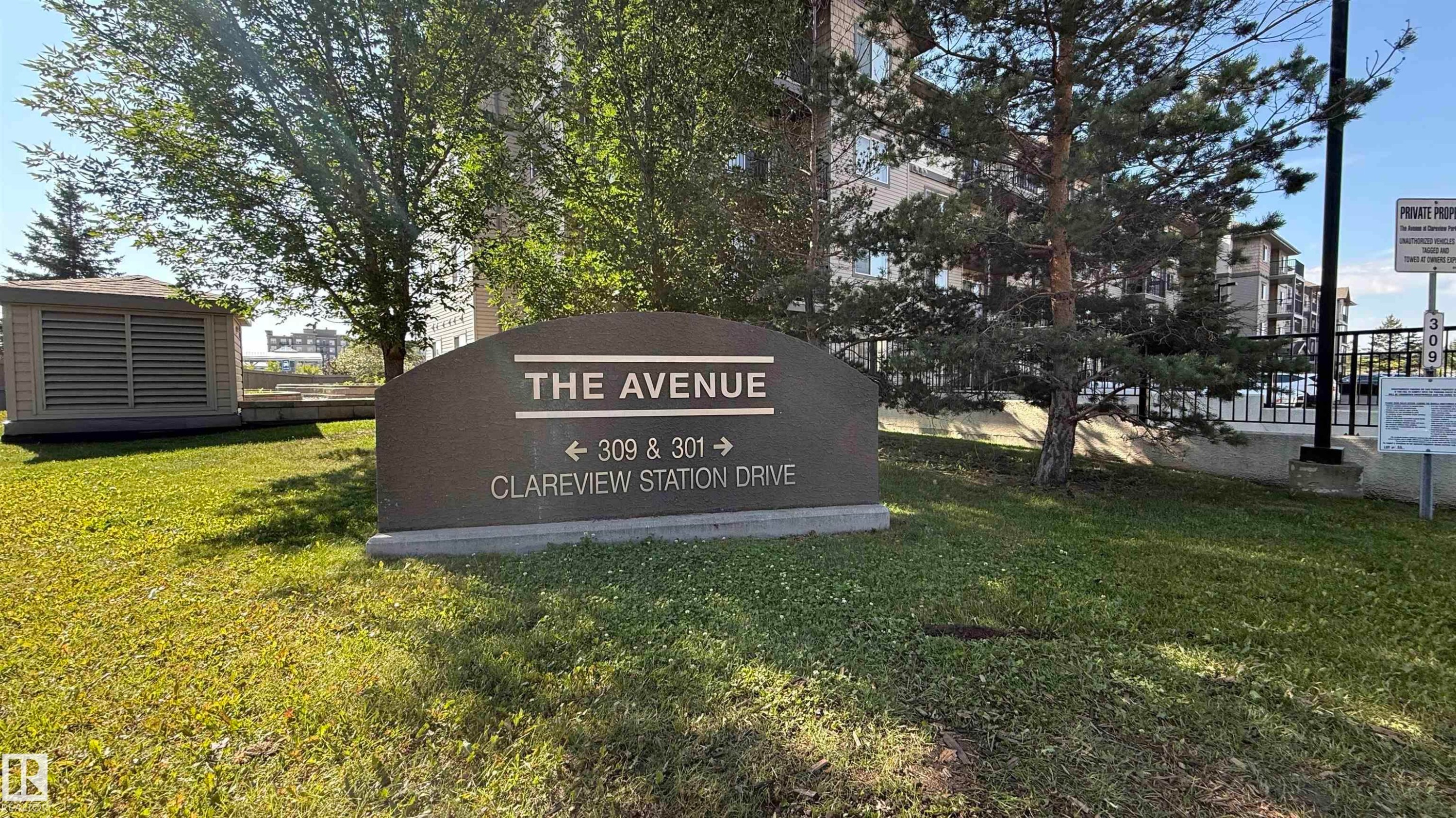 Property signage for "THE AVENUE" with directional arrows for addresses 309 and 301 Clareview Station Drive - 133 301 Clareview Station Drive, Edmonton, AB