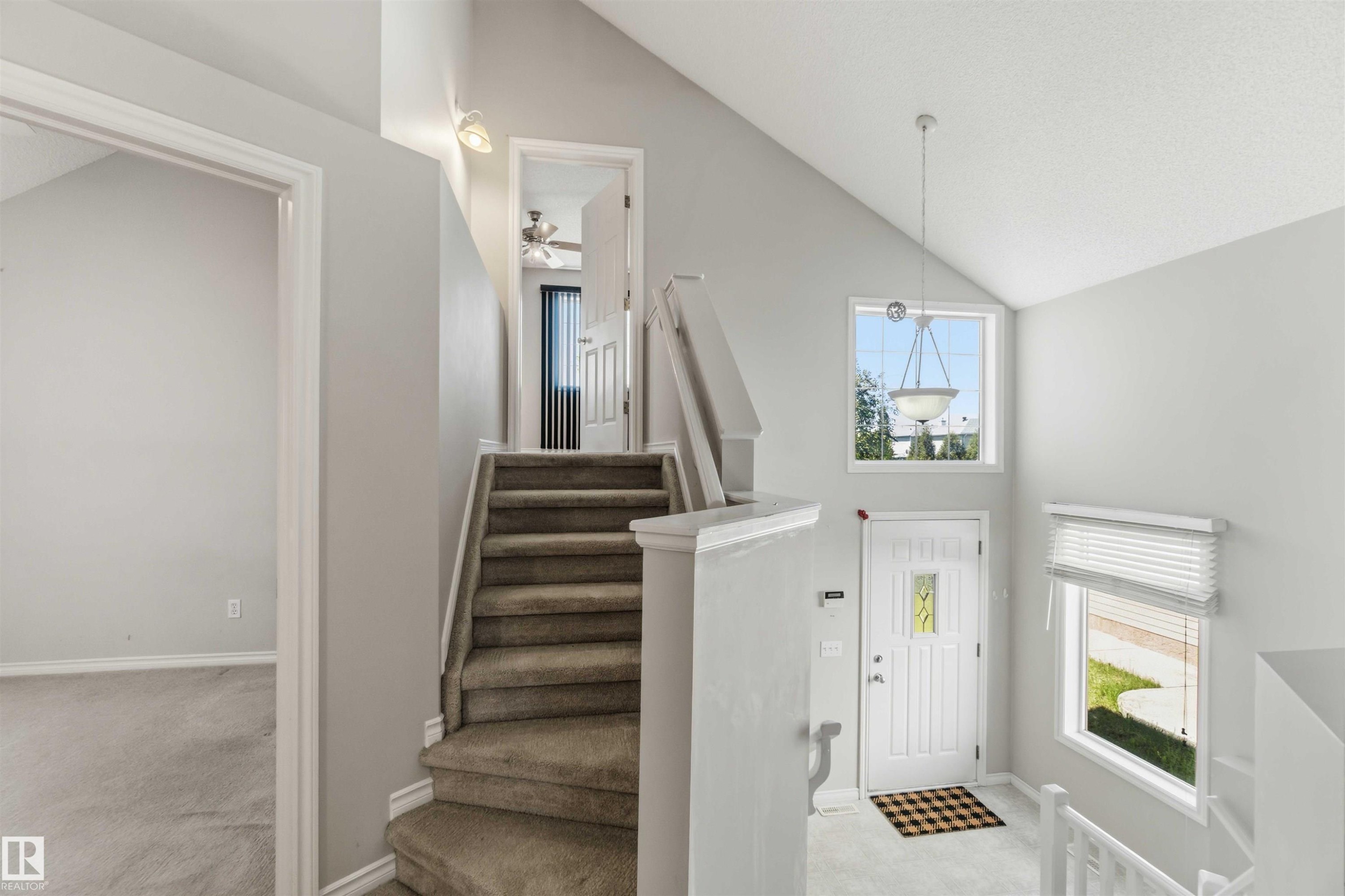 Carpeted staircase with white balusters leading to an upper level with an open doorway - 2012 35A Avenue, Edmonton, AB