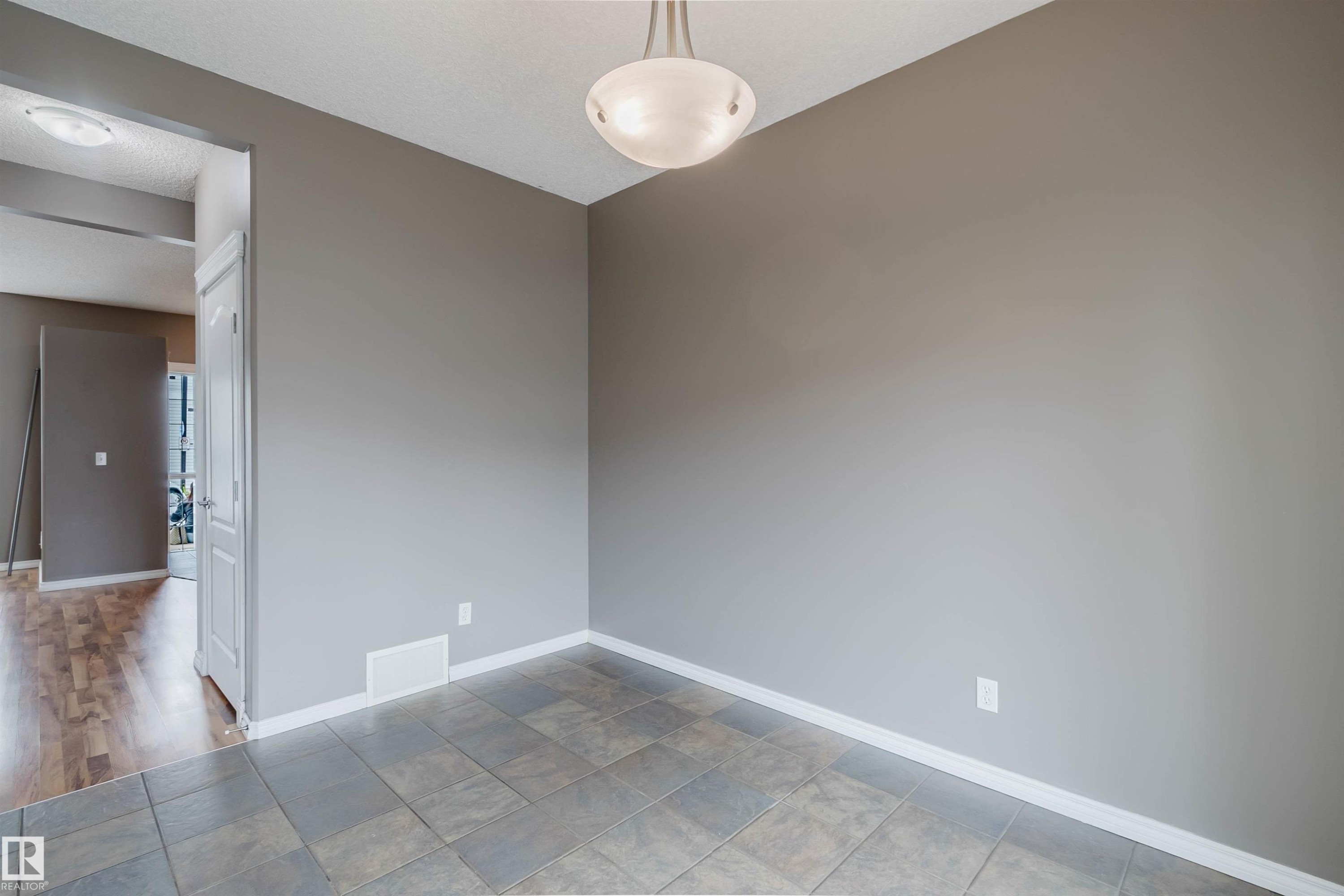 Room featuring gray tile flooring, neutral wall paint, and white baseboards - 38 1780 Glastonbury Boulevard, Edmonton, AB