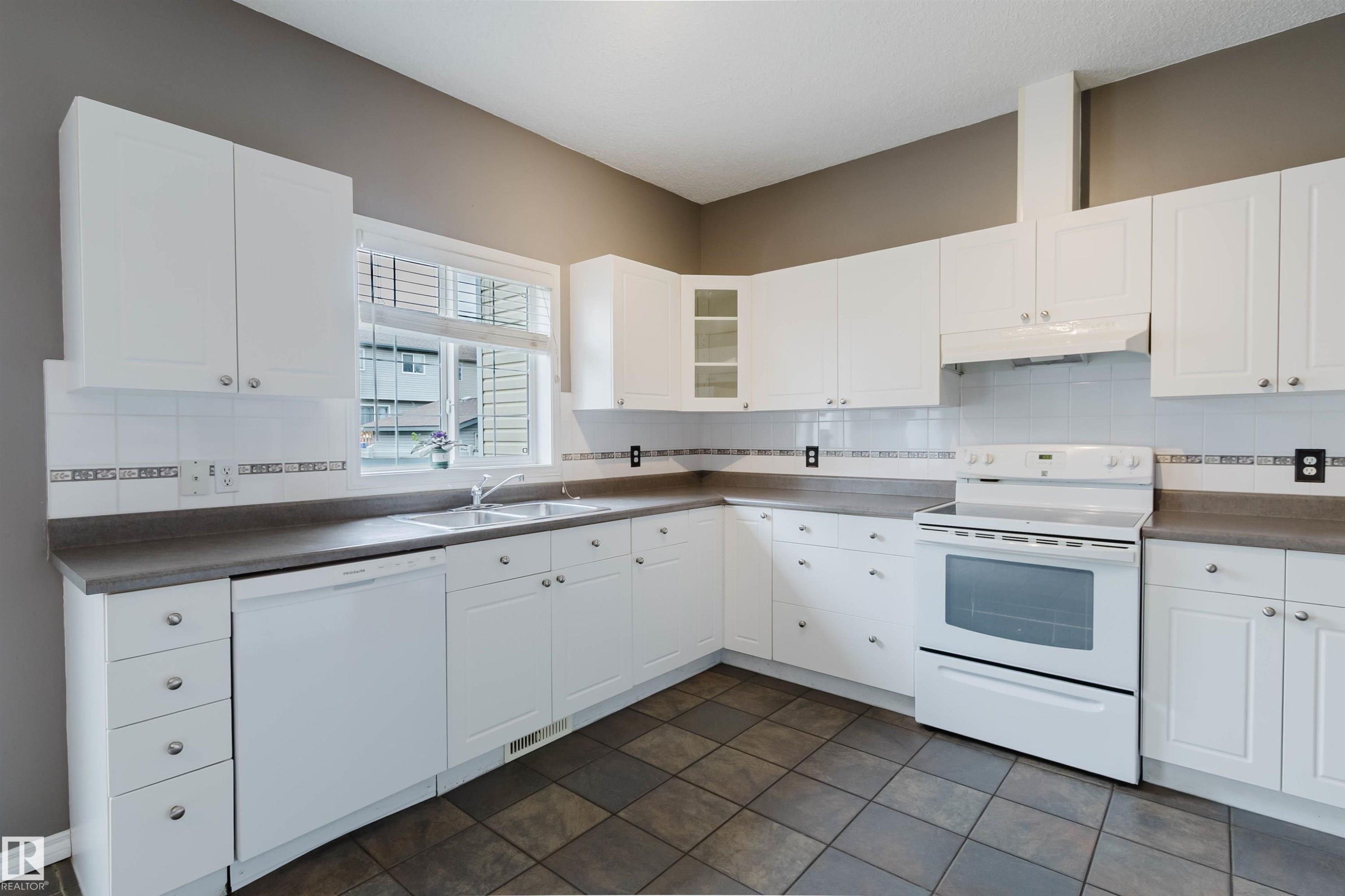 Kitchen featuring white cabinetry, gray countertops, and tiled flooring - 38 1780 Glastonbury Boulevard, Edmonton, AB