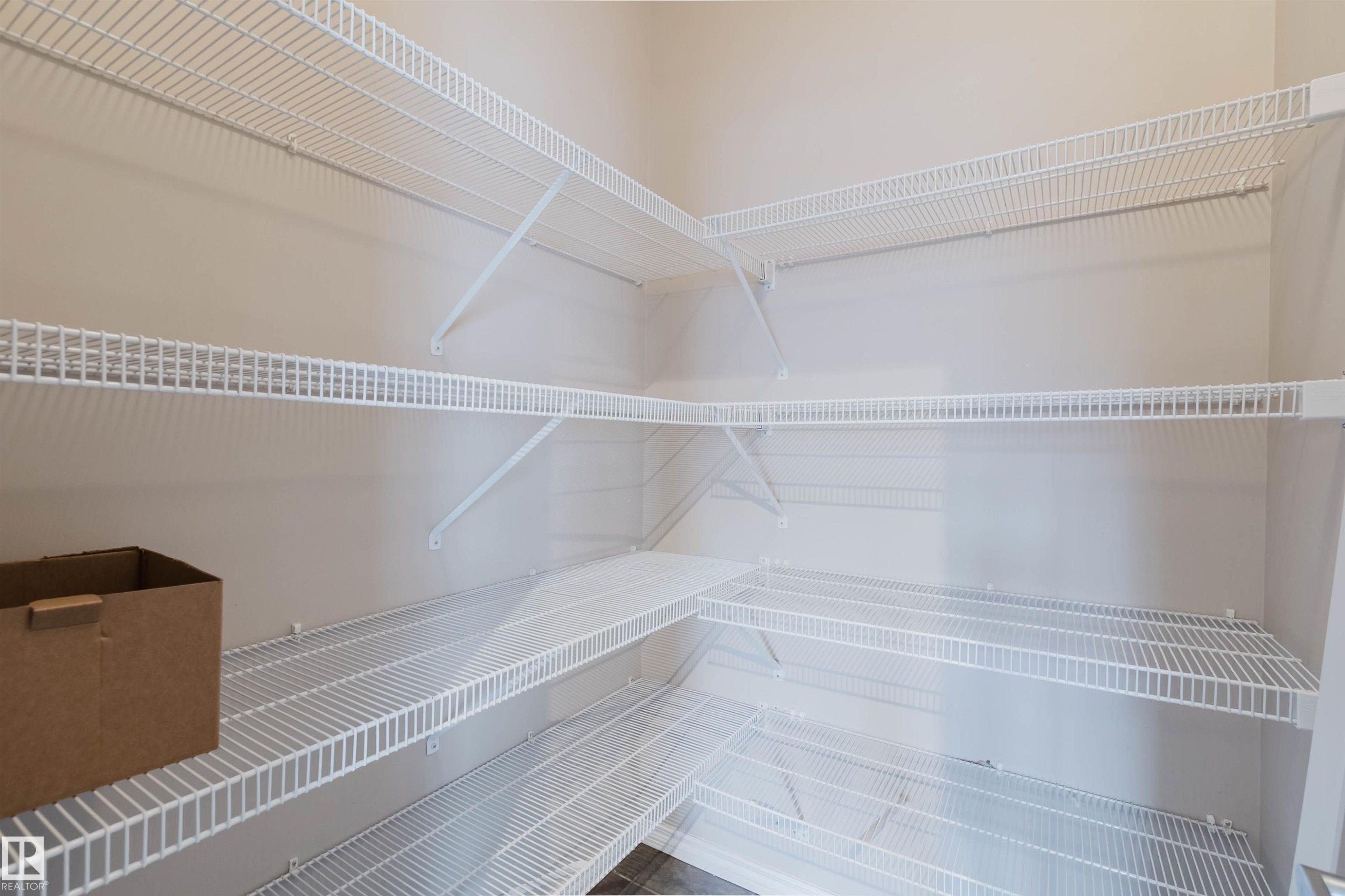 Corner pantry featuring multiple white wire shelving units - 38 1780 Glastonbury Boulevard, Edmonton, AB