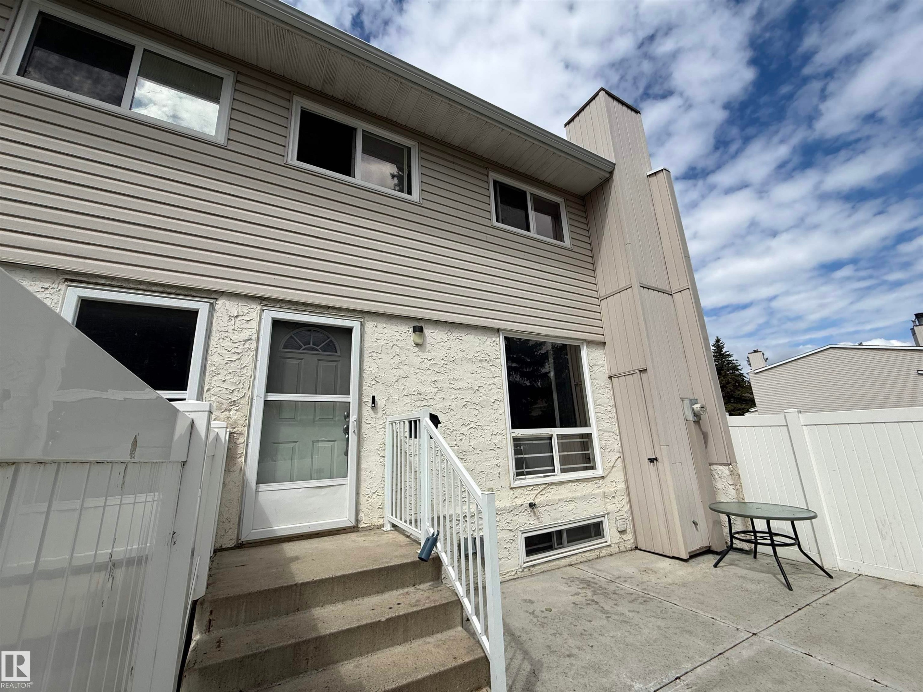 Multi-level exterior with light-colored siding and stucco finishes - 14537 121 Street, Edmonton, AB
