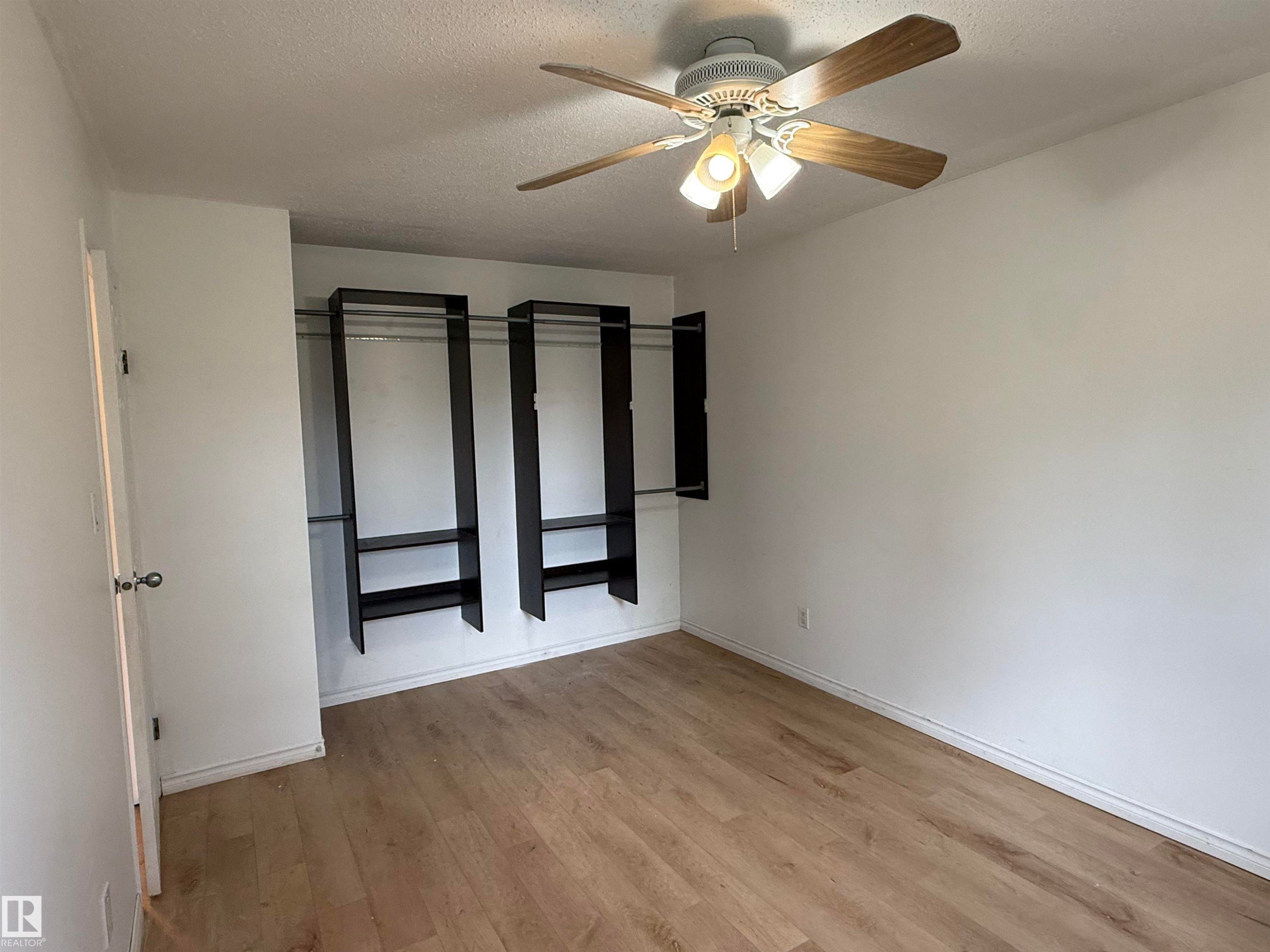 Interior room featuring wood-finish flooring and white walls - 14537 121 Street, Edmonton, AB