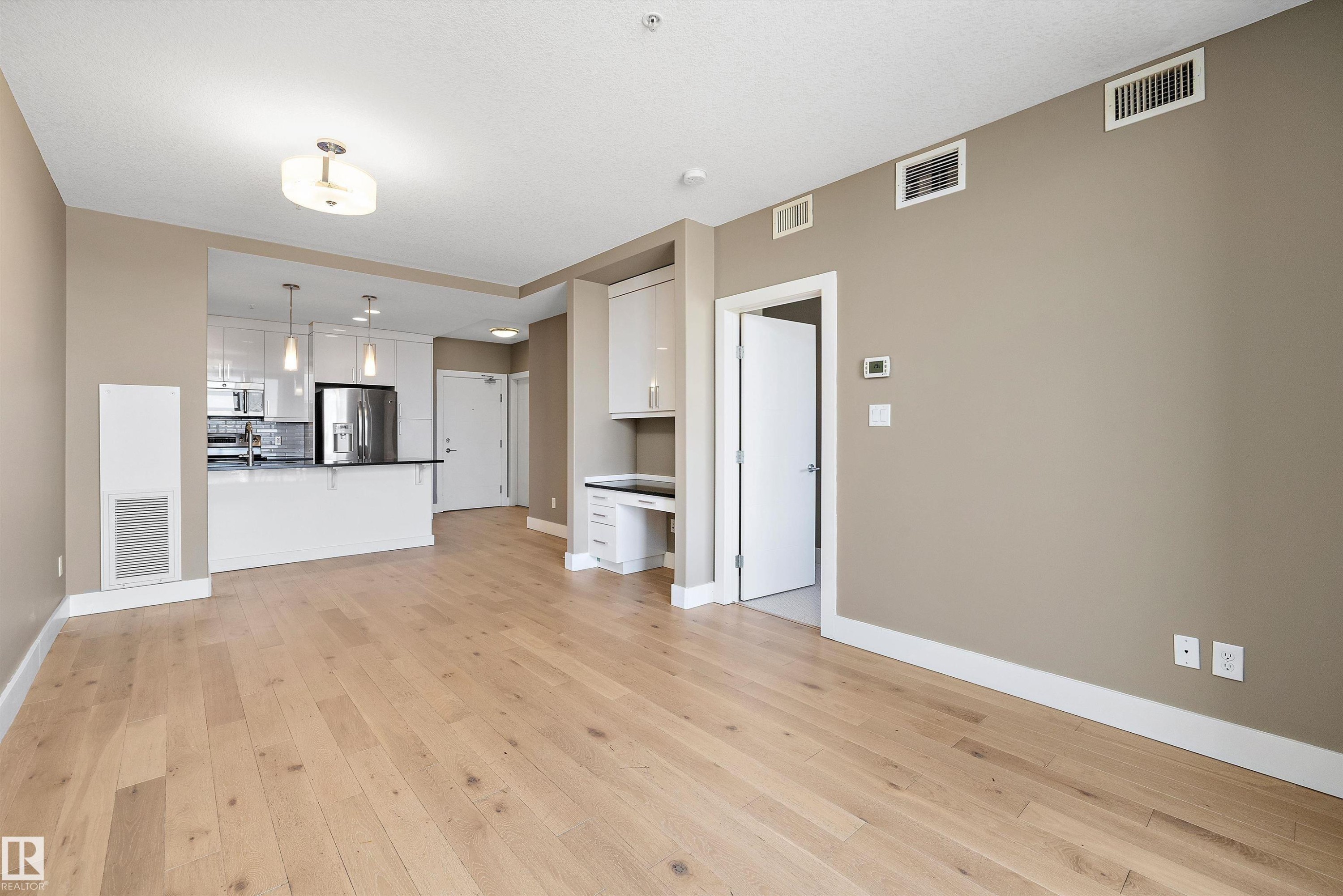 Open-concept living area featuring light wood-finish flooring - 307 11080 Ellerslie Rd Sw, Edmonton, AB
