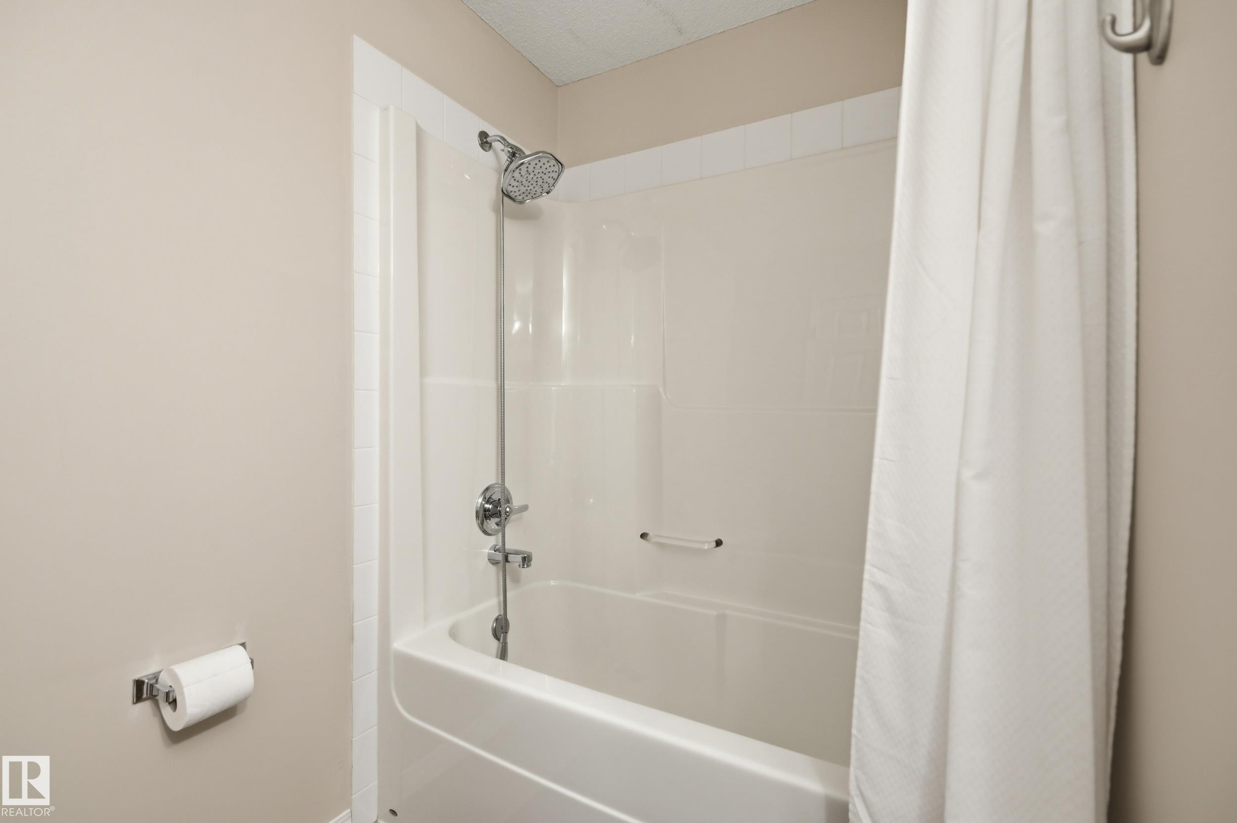 Bathtub and shower combination featuring a chrome fixtures, white subway tile surround, and a coordinating white shower curtain - 11628 167A Avenue, Edmonton, AB - Indoor Photo Showing Bathroom