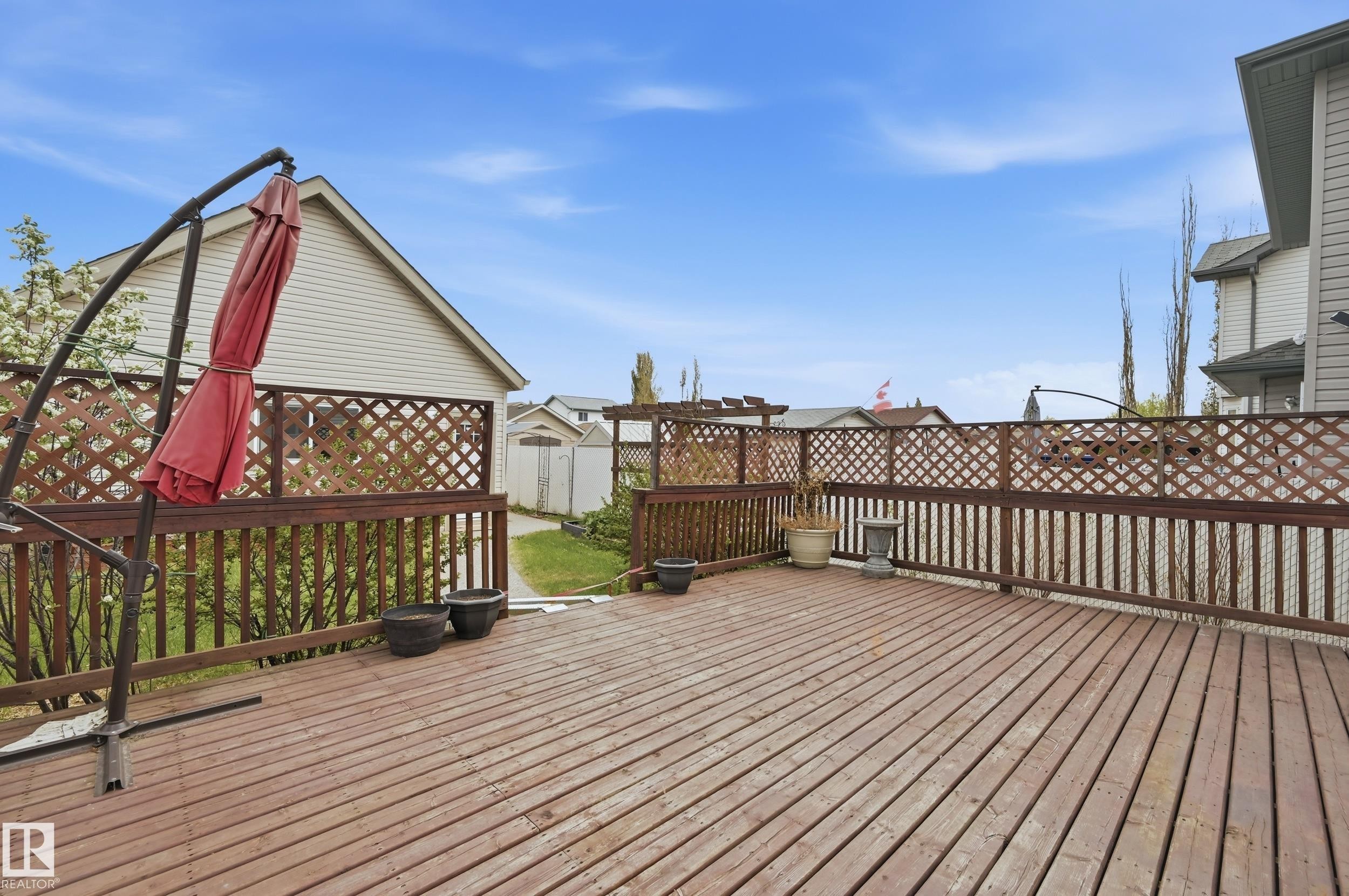 Expansive wood-finish deck featuring a full perimeter railing with lattice accents - 11628 167A Avenue, Edmonton, AB - Outdoor With Exterior