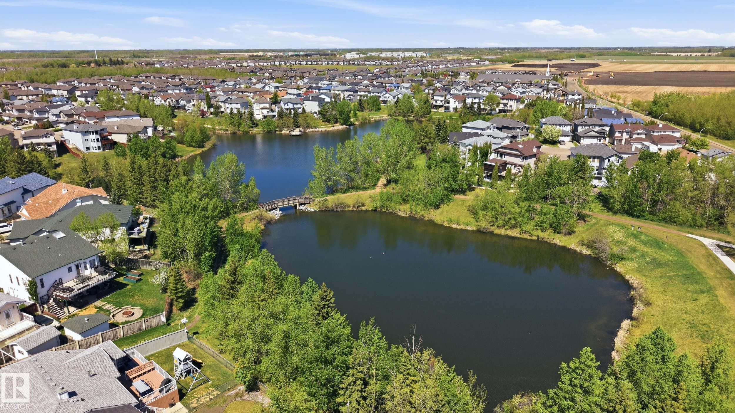 Aerial perspective showcasing a residential community with a central water feature - 11628 167A Avenue, Edmonton, AB - Outdoor With Body Of Water With View